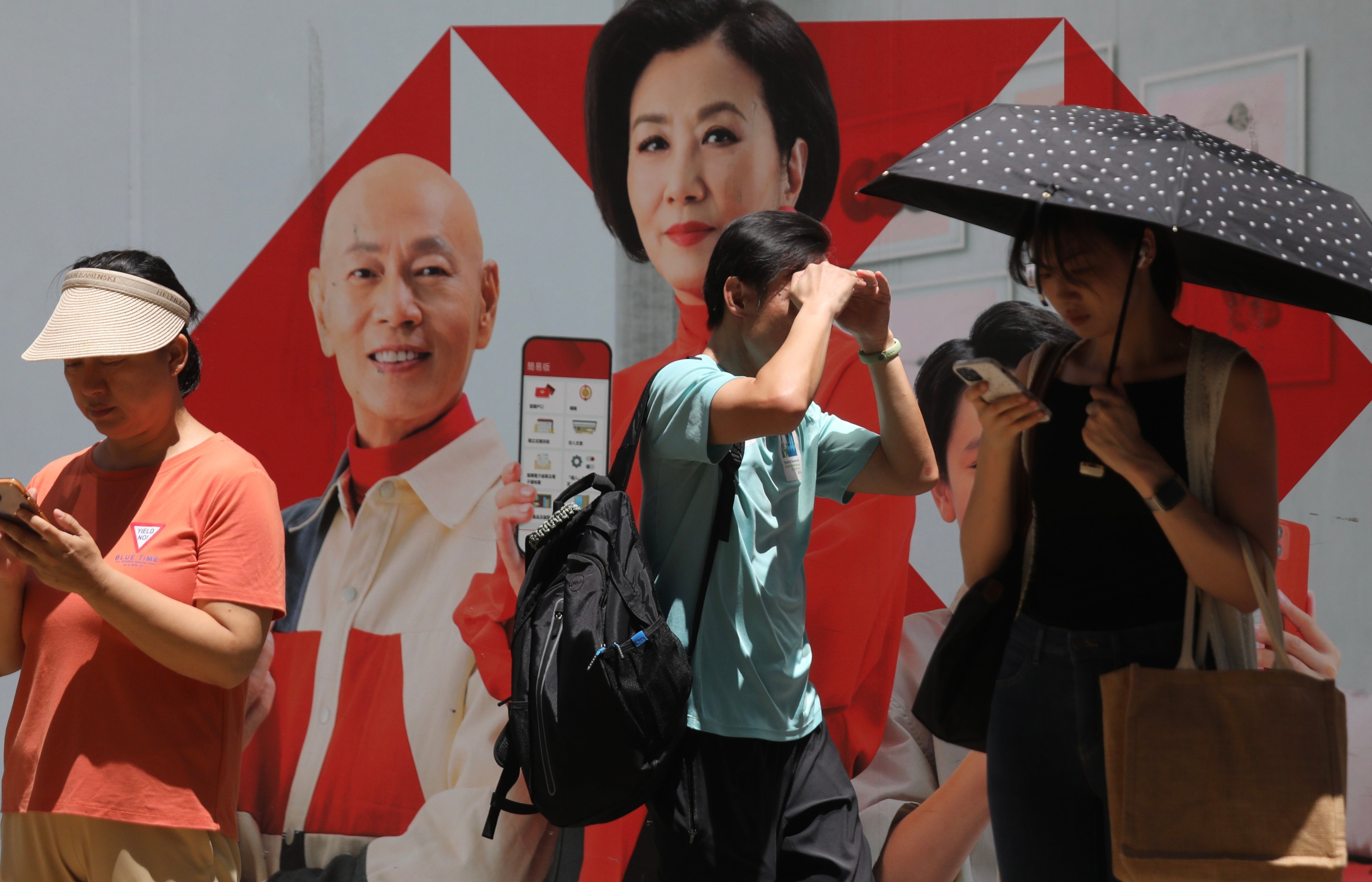 Hong Kong residents in front of an advertising billboard with HSBC’s logo in Kwun Tong on 8 July 2023. Photo: Xiaomei Chen