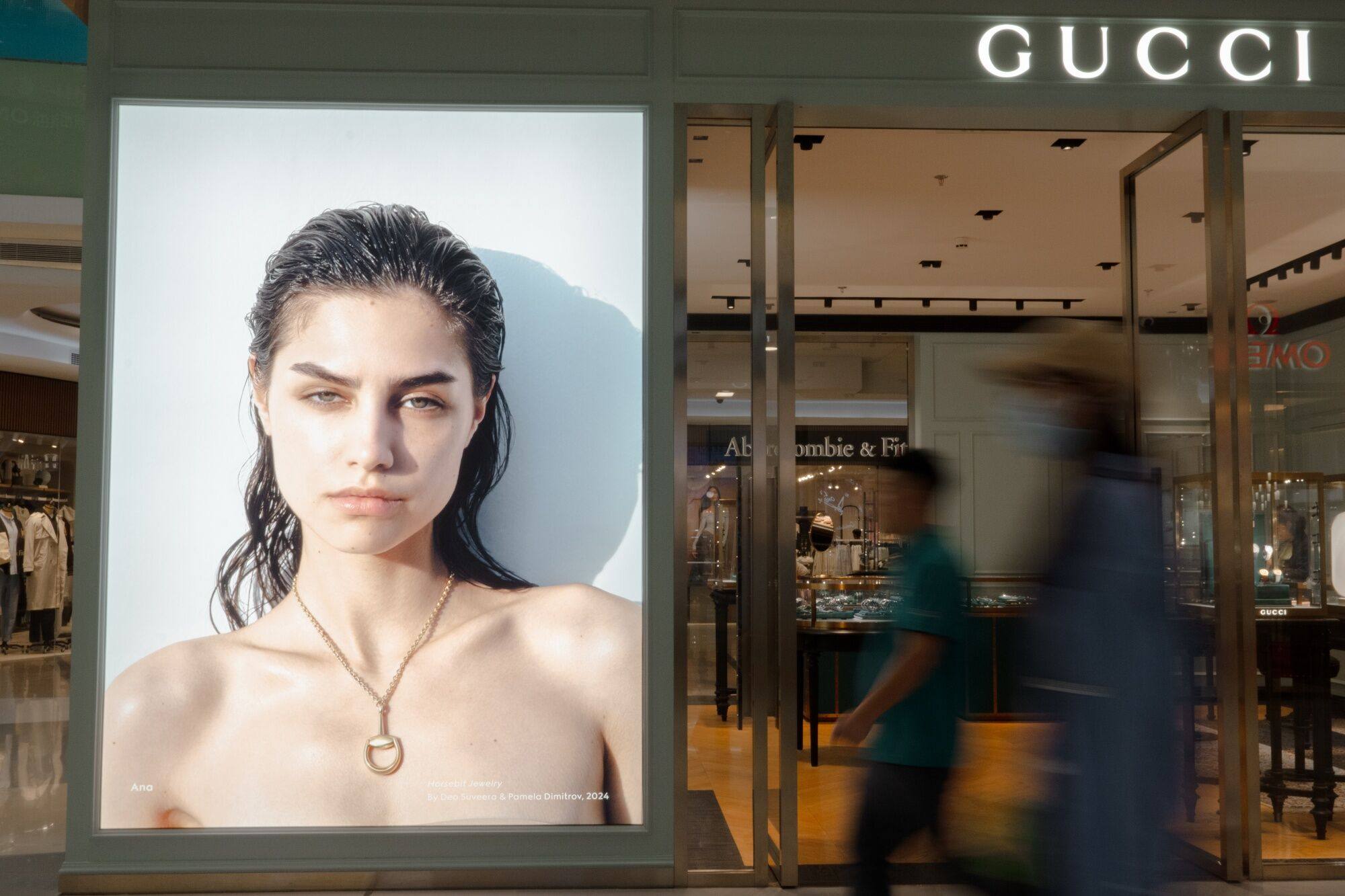 People walk past a Gucci store in the Wangfujing shopping area in Beijing on September 13. China’s slowing growth has begun to weigh on luxury brands. Photo: Bloomberg