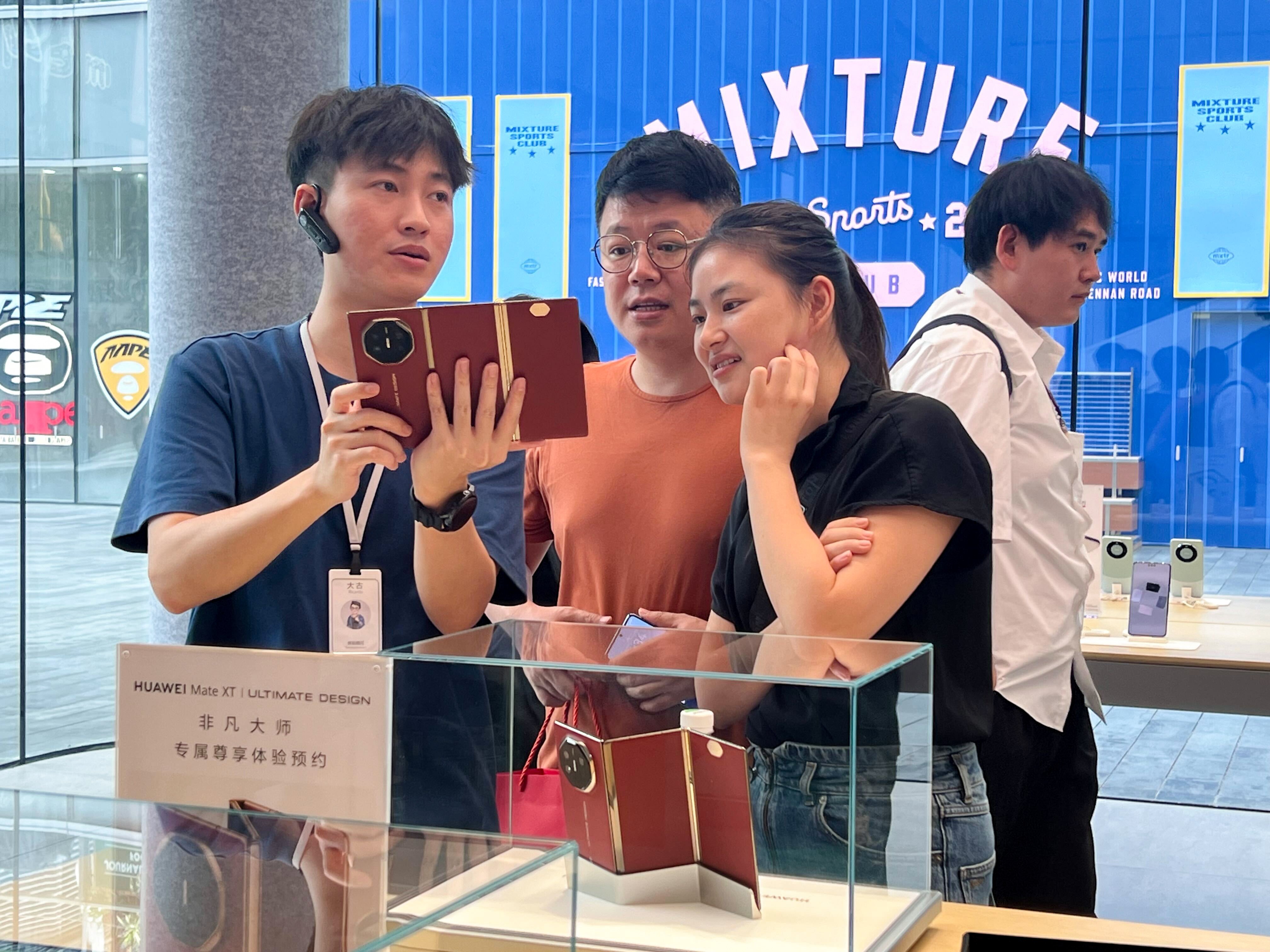 Huawei sales staff demonstrate the Mate XT tri-fold smartphone in its Shenzhen store on Friday. Photo: Iris Deng