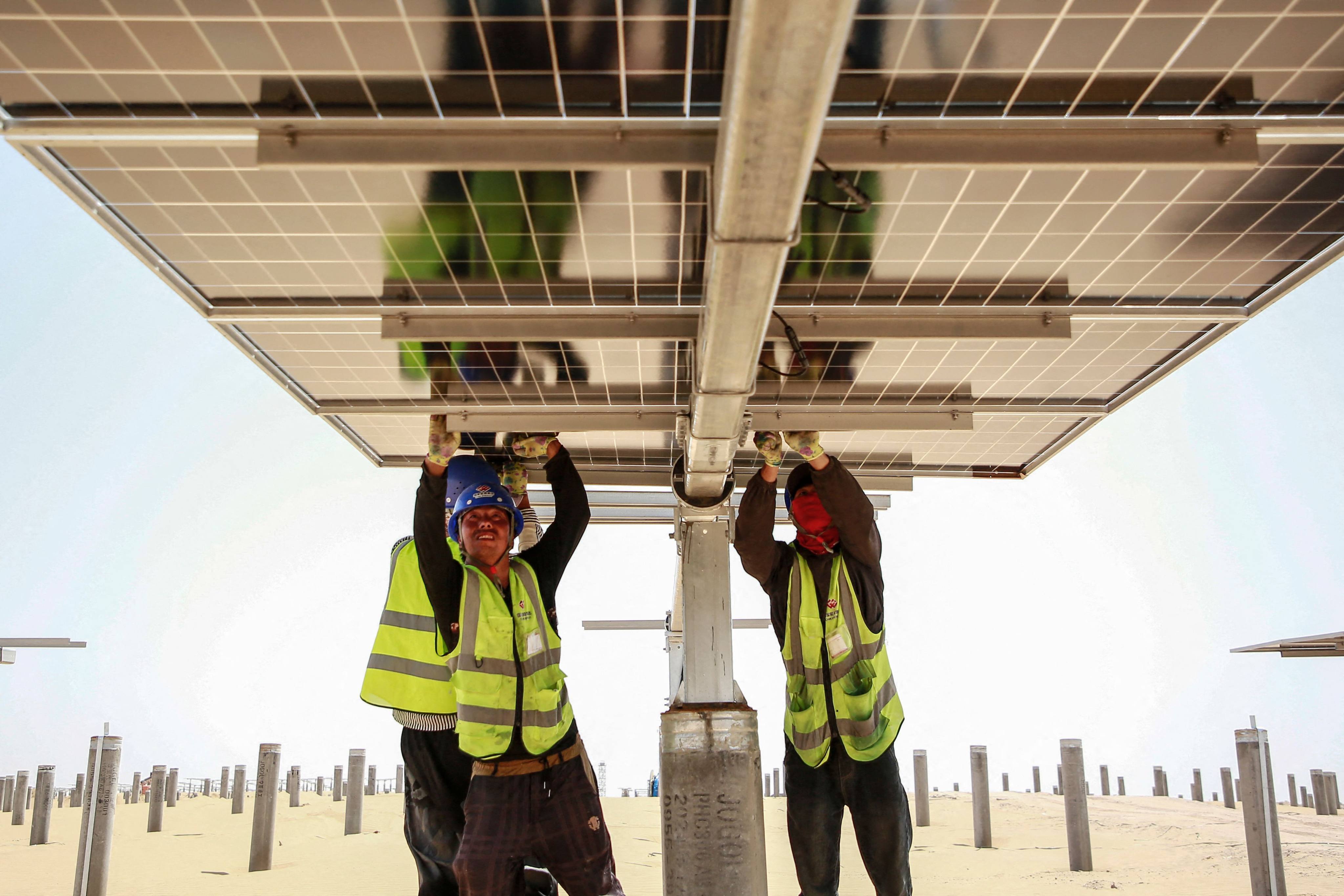 Workers install solar panels at an energy base in  Zhongwei, Ningxia Hu autonomous region, on May 9. Photo: AFP