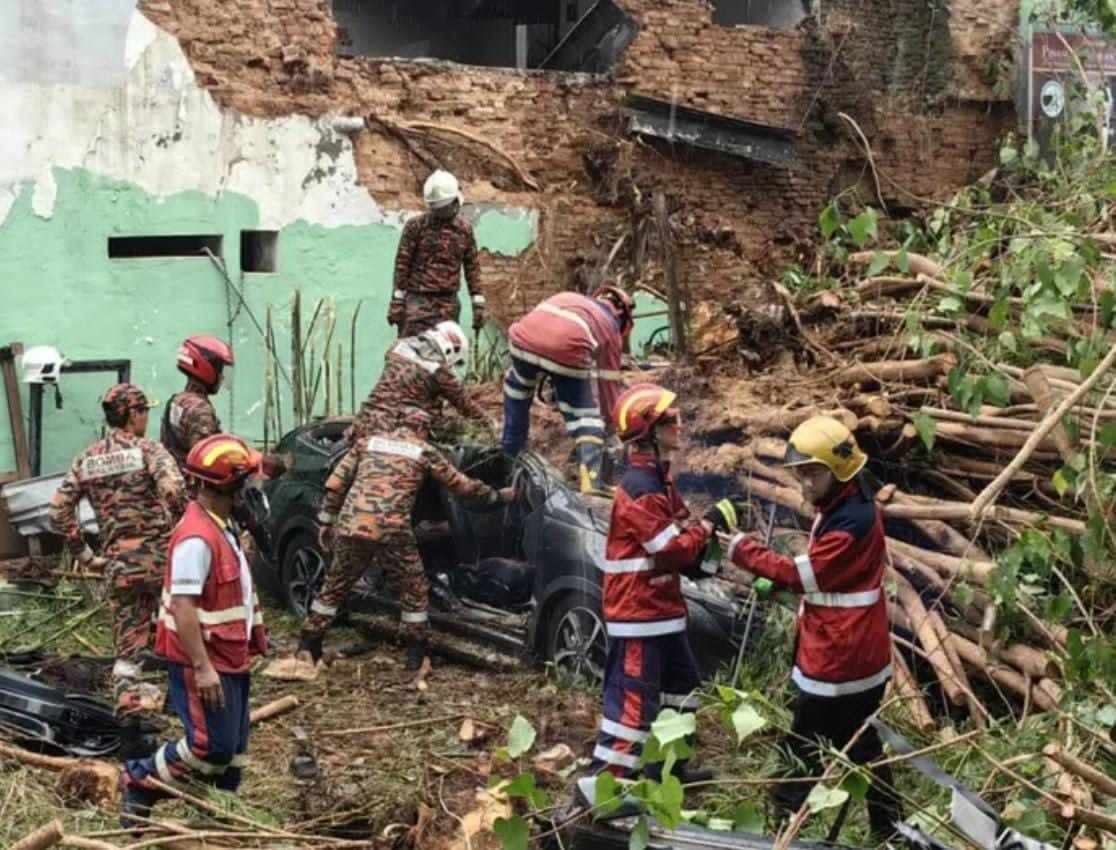 Rescuers remove the bodies of the victims from the car wreckage in Penang. Photo: Facebook/BombaMalaysiaOfficial
