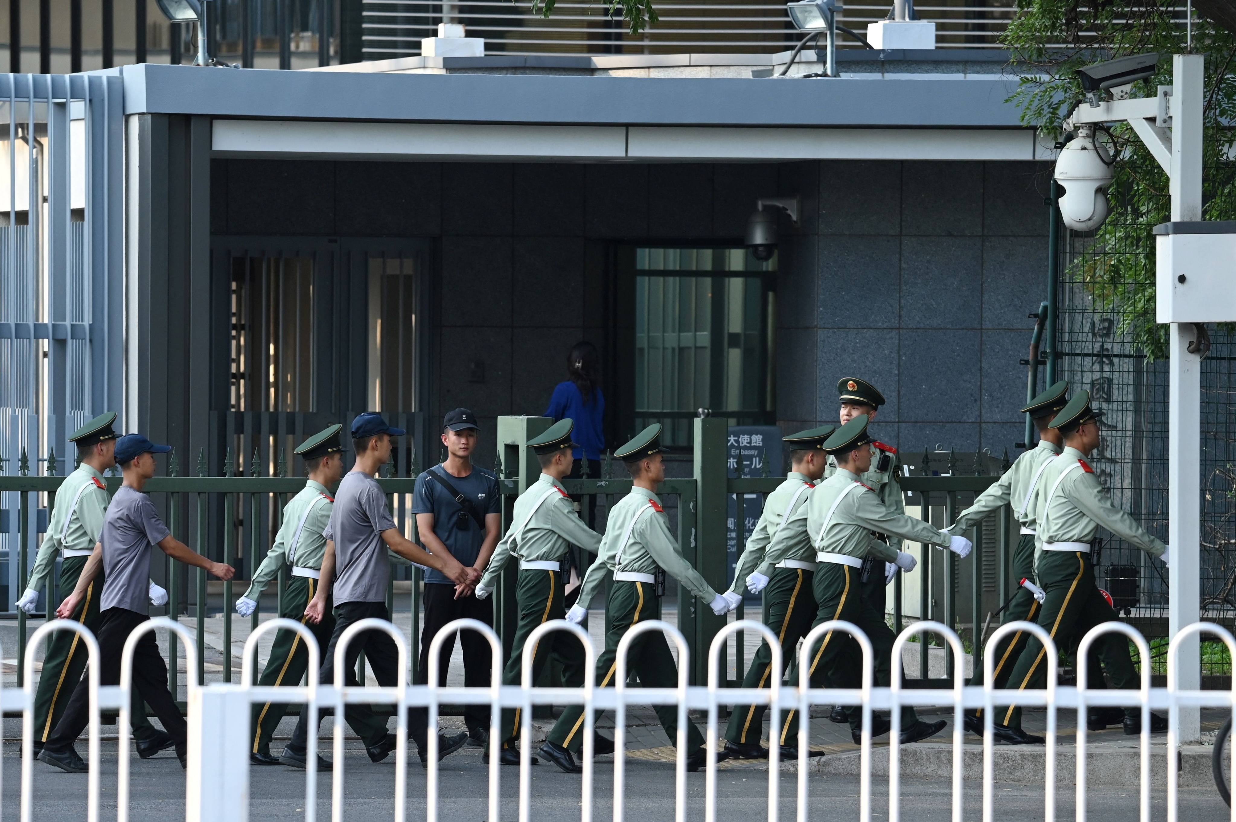 Chinese paramilitary police officers march past the entrance of the Japanese embassy in Beijing on Thursday. China has expressed “regret and sadness” after a Japanese schoolboy died after being stabbed on Wednesday. Photo: AFP