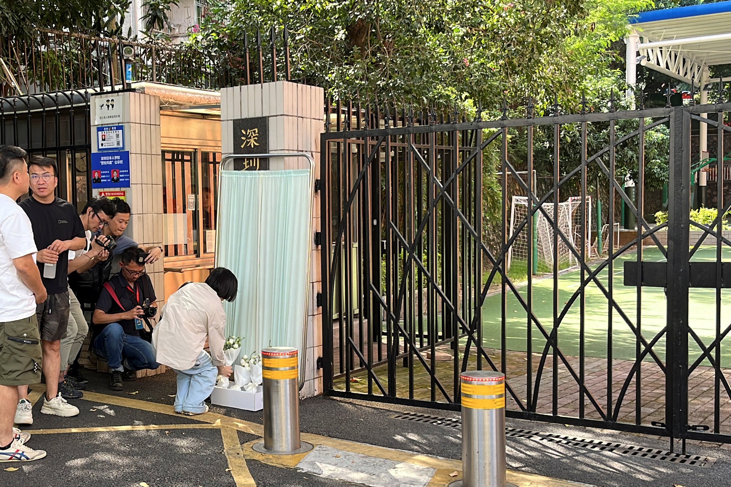 A woman lays flowers outside a school in Shenzhen attended by a Japanese boy who died after being stabbed on his way to the school on Wednesday. Photo: Reuters 