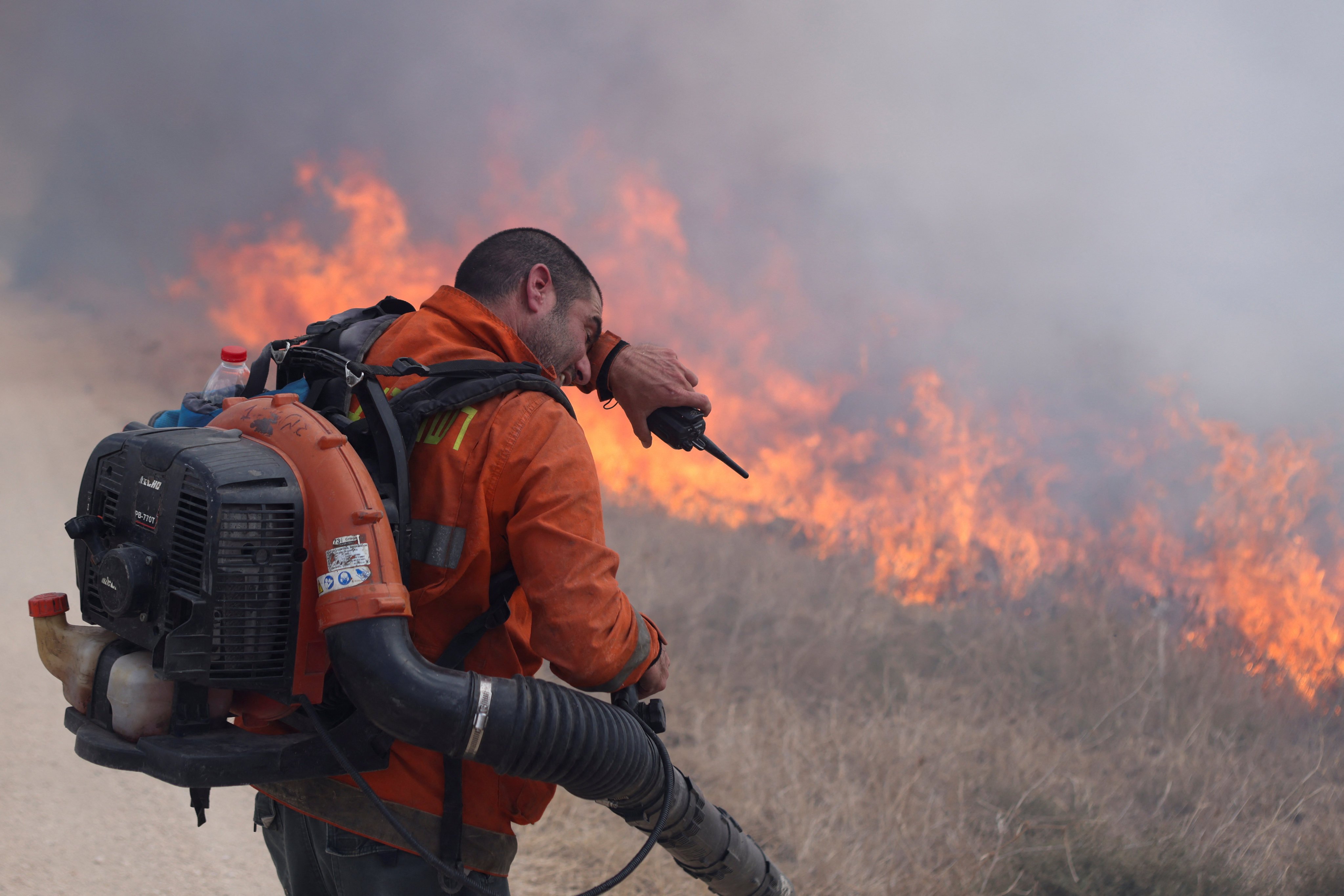 A man tries to extinguish flames following a rocket attack from Lebanon, in the Israeli-occupied Golan Heights. Photo: Reuters