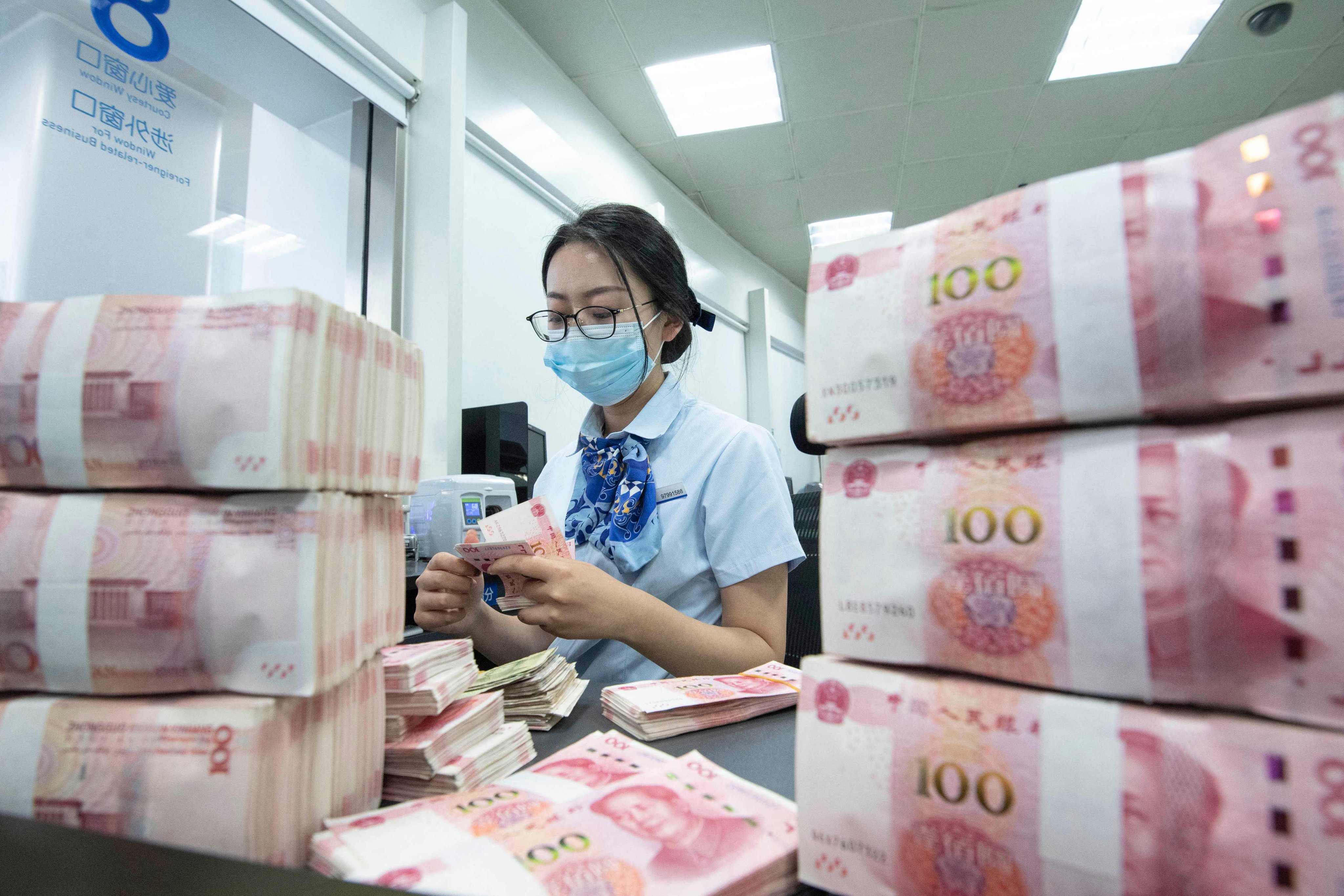 A bank employee counting notes at a bank counter in Nanjing, in China’s eastern Jiangsu province. Photo: AFP