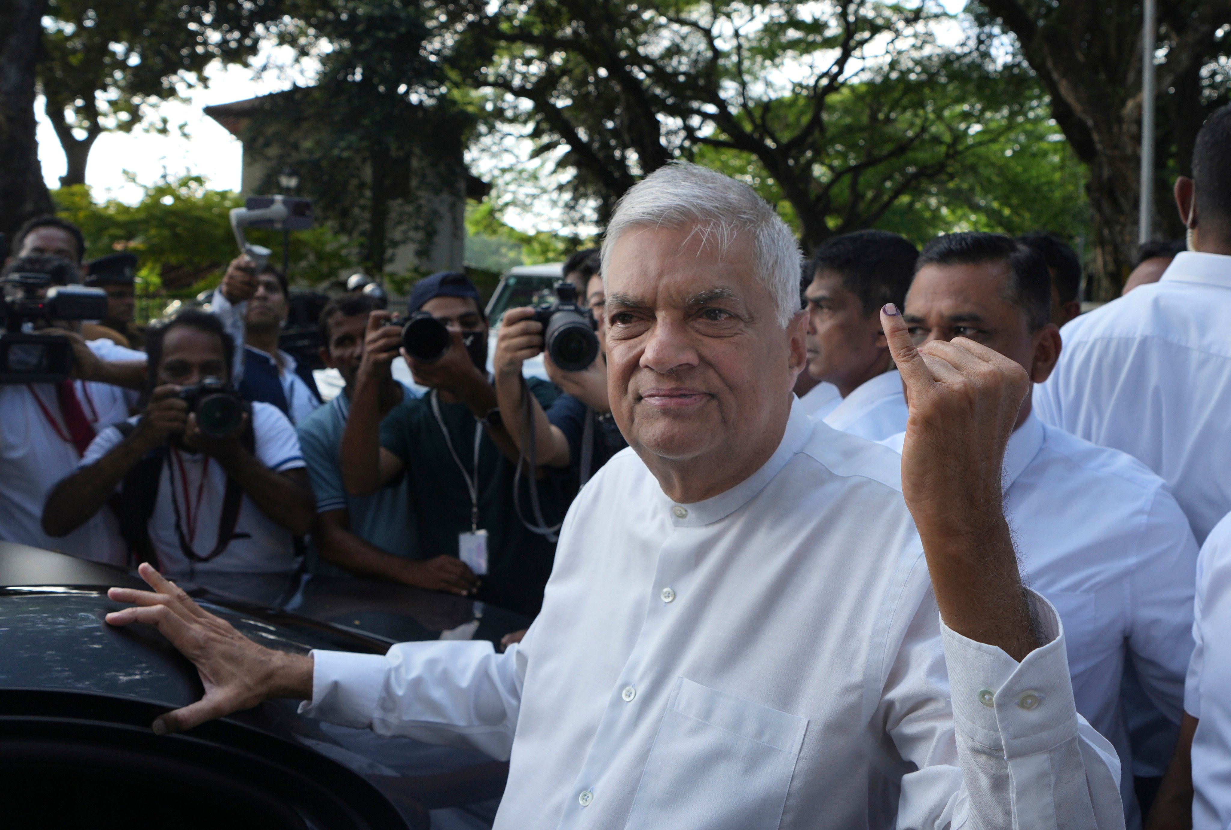 Sri Lankan president Ranil Wickremesinghe shows an indelible mark on his baby finger after casting his vote on Saturday. Photo: AP