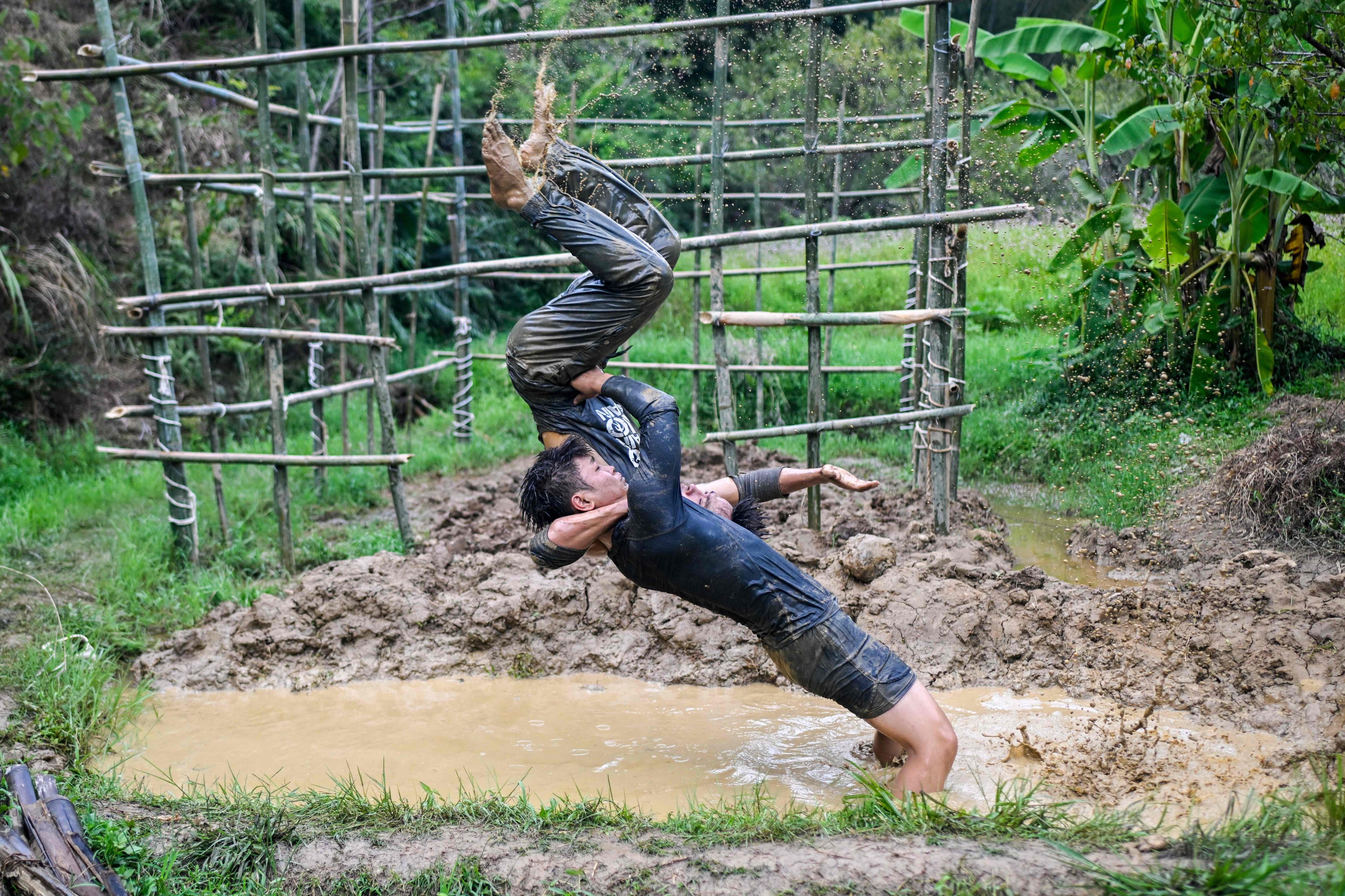 Wang Tao (right) trains with teammate Chen Wenbin in a mud puddle in the mountain forest in Xingning, in the China southern Guangdong province. Photo: AFP