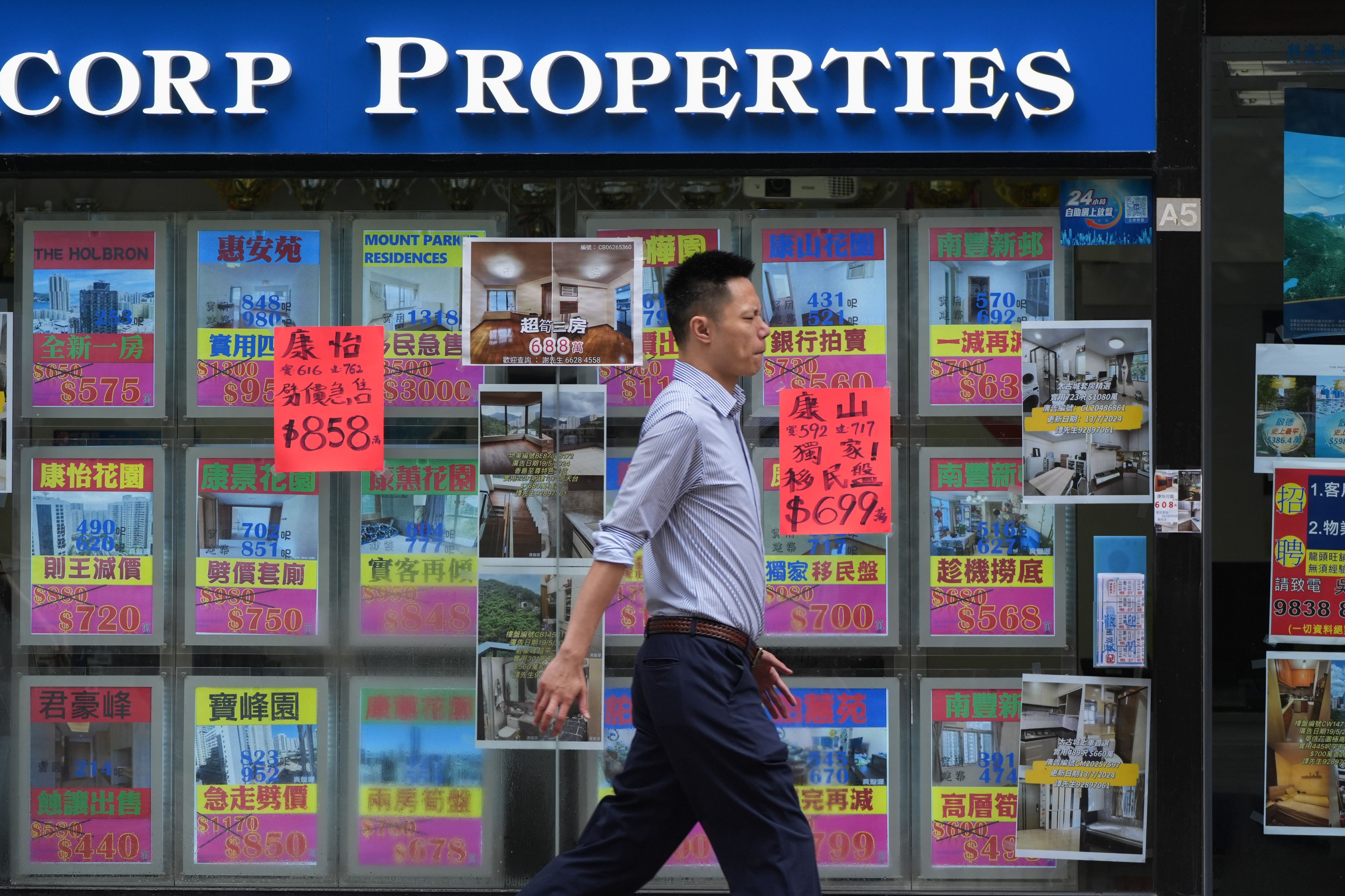 A man passed a real estate agency in Taikoo. Photo: SCMP/Eugene Lee