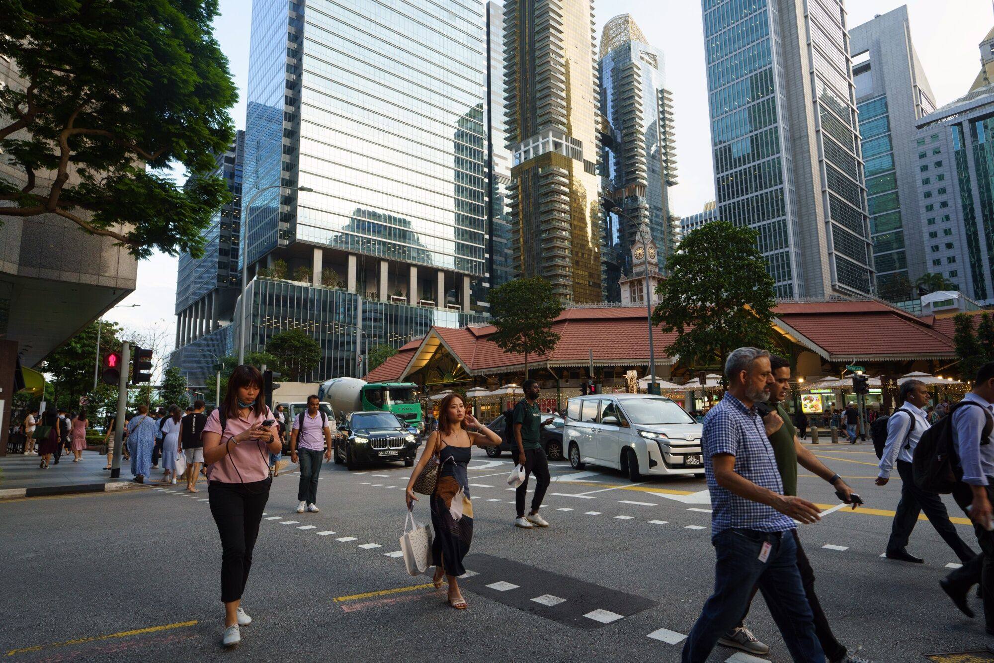 Pedestrians pass commercial buildings in Singapore’s central business district on April 11. Photo: Bloomberg