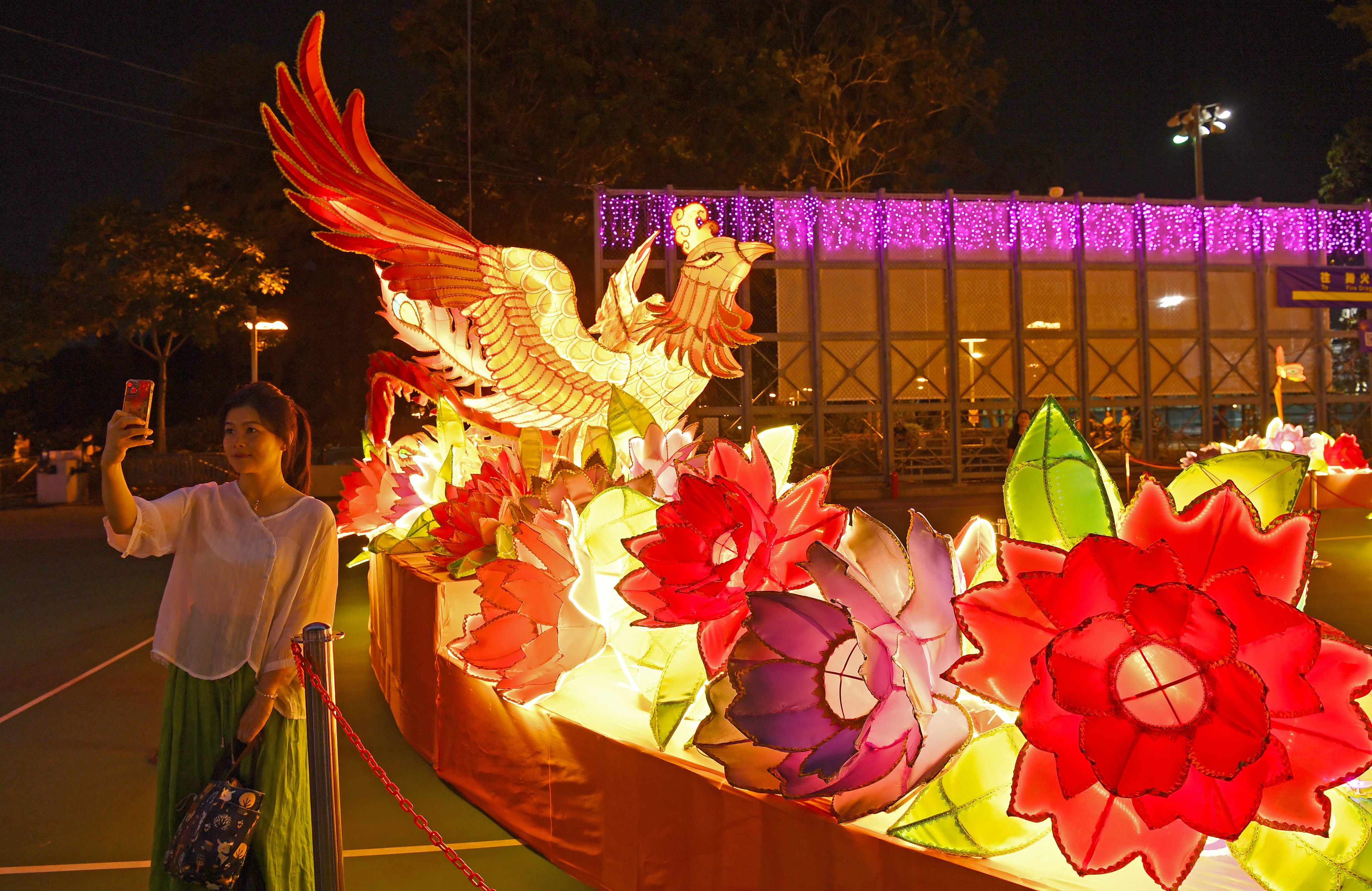 A woman takes selfies at a lantern fair marking the Mid-Autumn Festival and National Day at Victoria Park on September 12. Photo: Xinhua