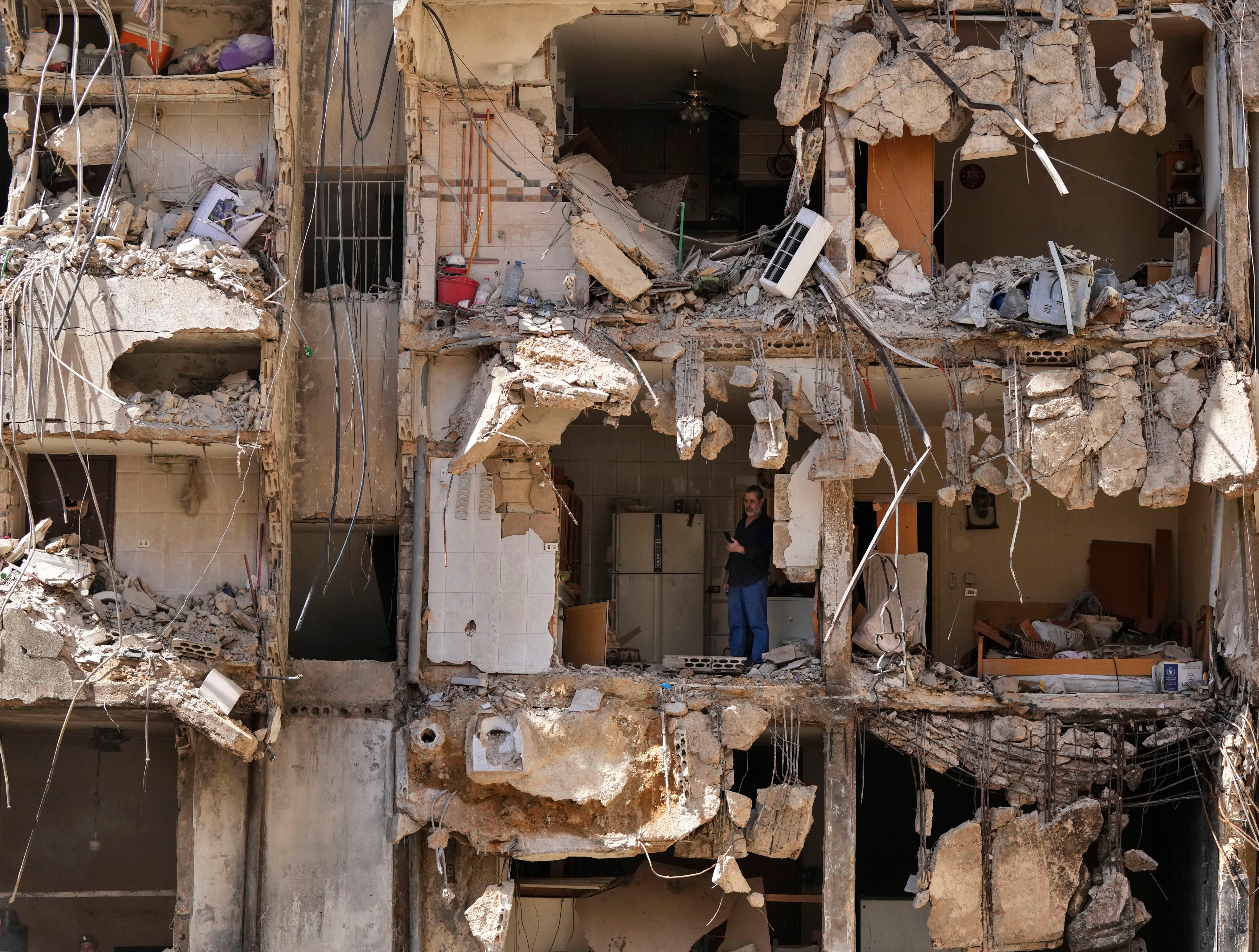 A man watches rescuers sift through rubble after an Israeli strike in Beirut’s southern suburbs. Photo: AP