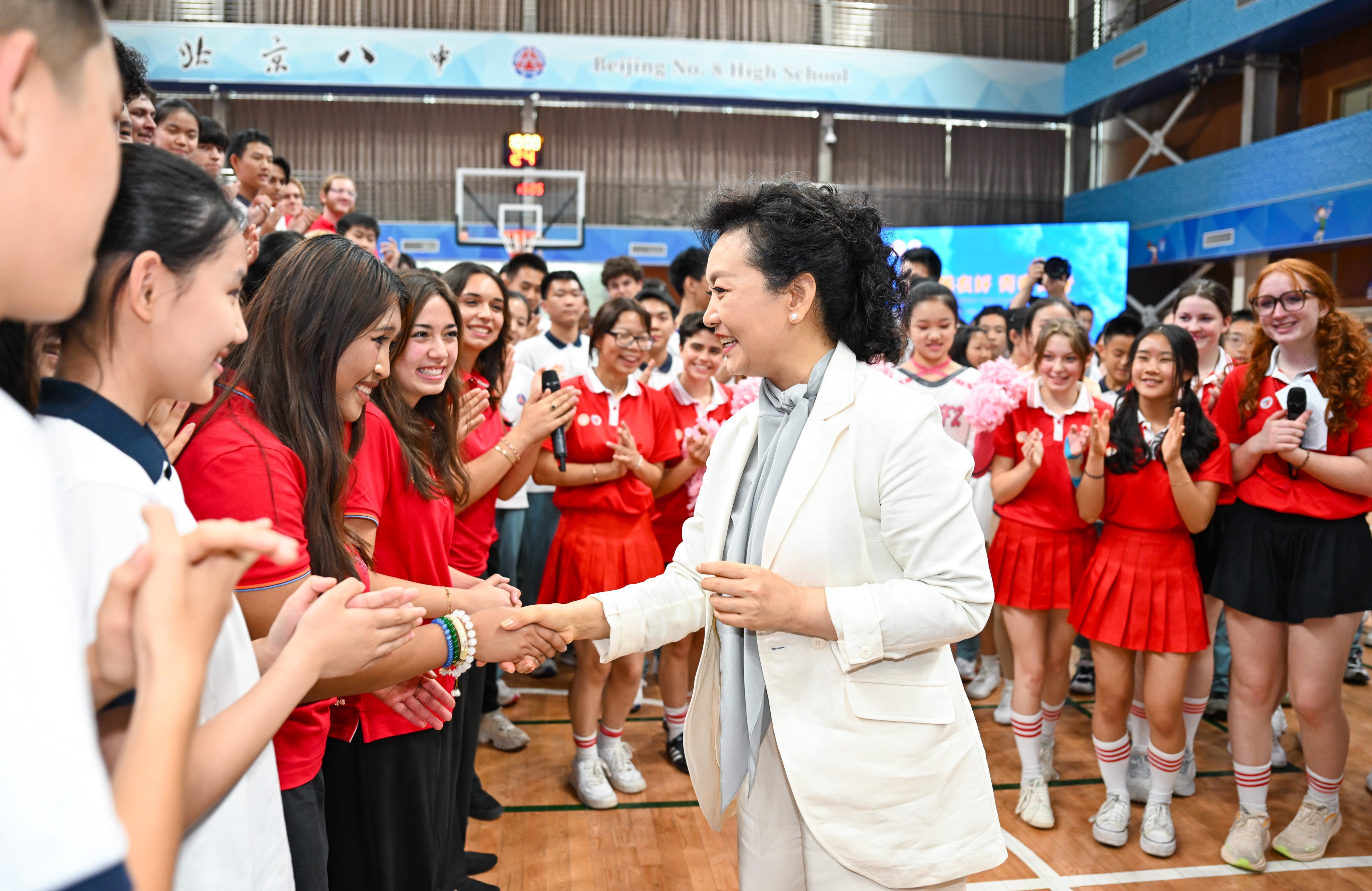 Peng Liyuan, wife of Chinese President Xi Jinping, shakes hands with students at Beijing No. 8 High School during a sports and culture event on Tuesday. Photo: Xinhua