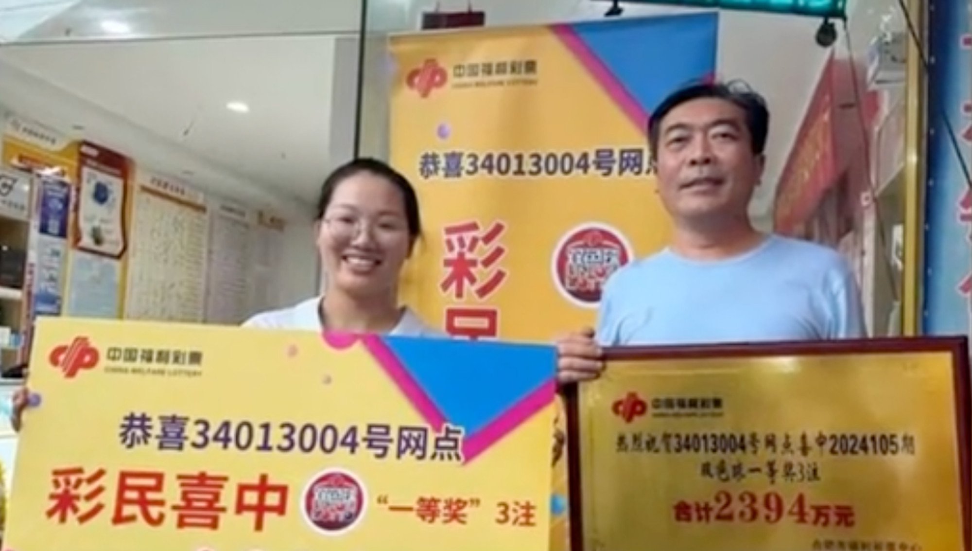 Eyes on the prize: winner Huang, right, is all smiles as he collects his lottery windfall. Photo: Baidu