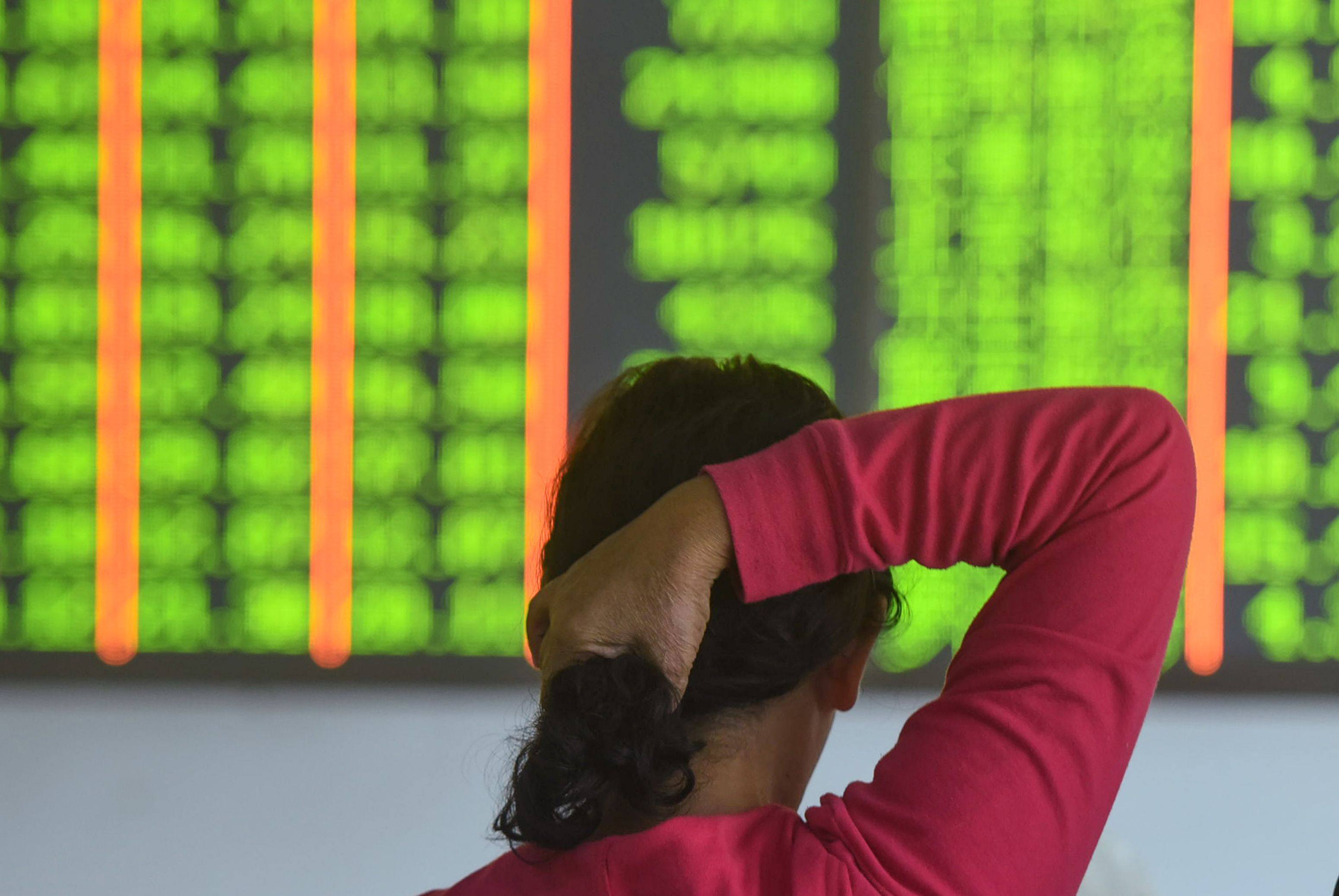 A investor monitors stock prices at a securities company in Hangzhou in China’s eastern Zhejiang province on October 18, 2018. Contrary to global convention, China represents losses and declines in green, and uses red to illustrate gains and profits. Photo: AFP