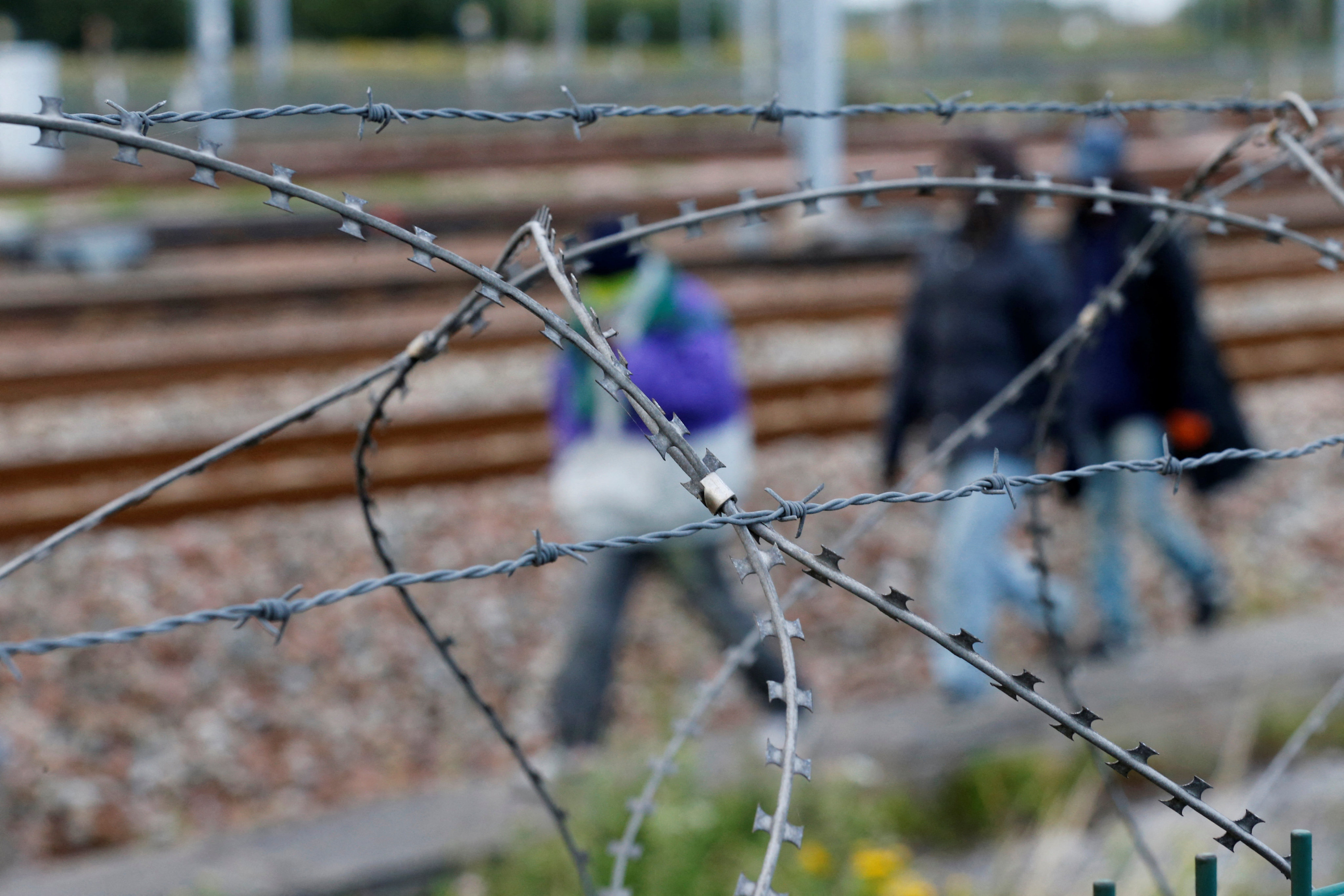 Razor-wire frames migrants who walk near train tracks which lead to the Channel Tunnel in Frethun, near Calais, France. Photo: Reuters