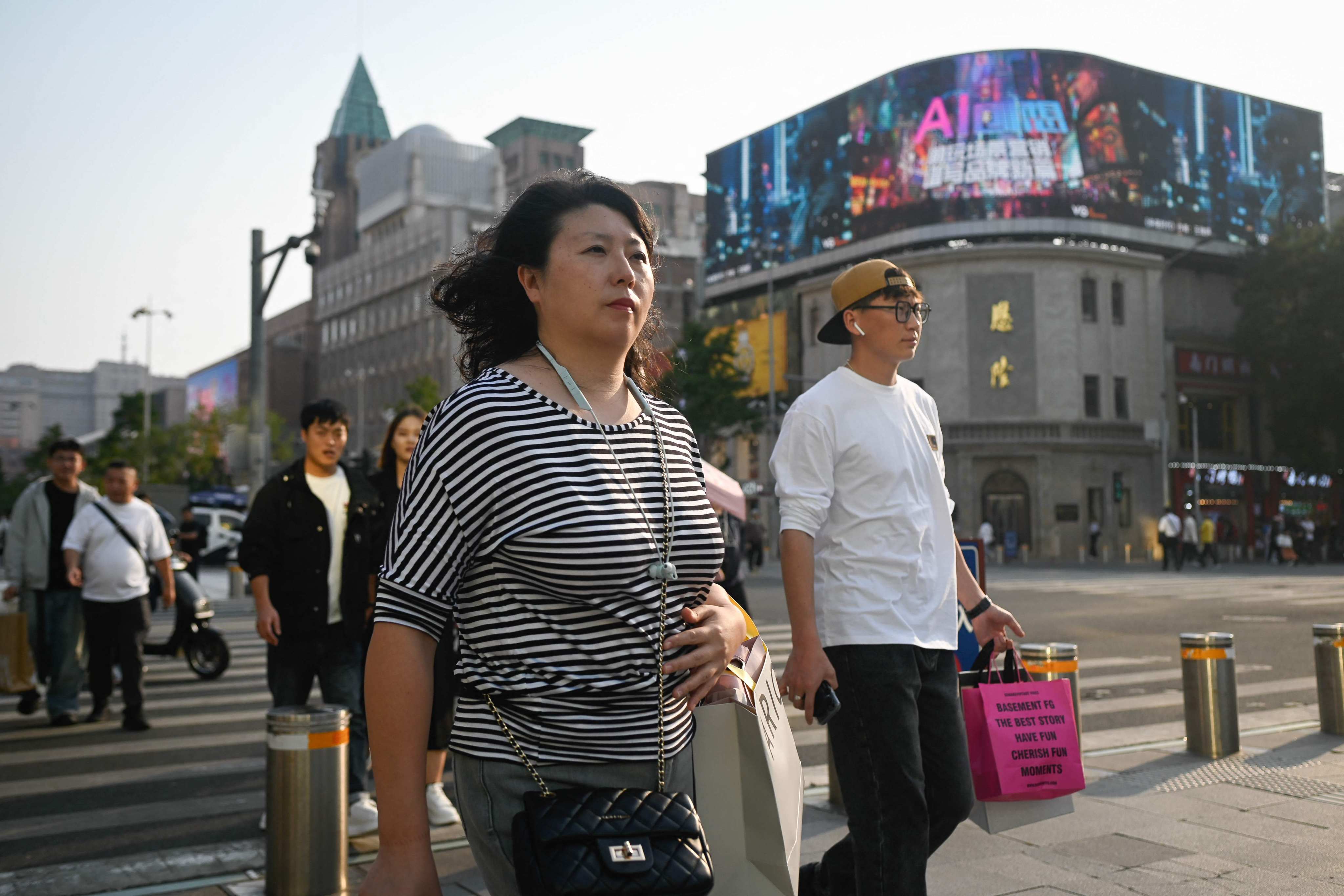 People cross a street in a business district in Beijing on September 24. China’s current economic challenges mainly stem from deeper structural problems, rather than a withdrawal of foreign investments. Photo: AFP