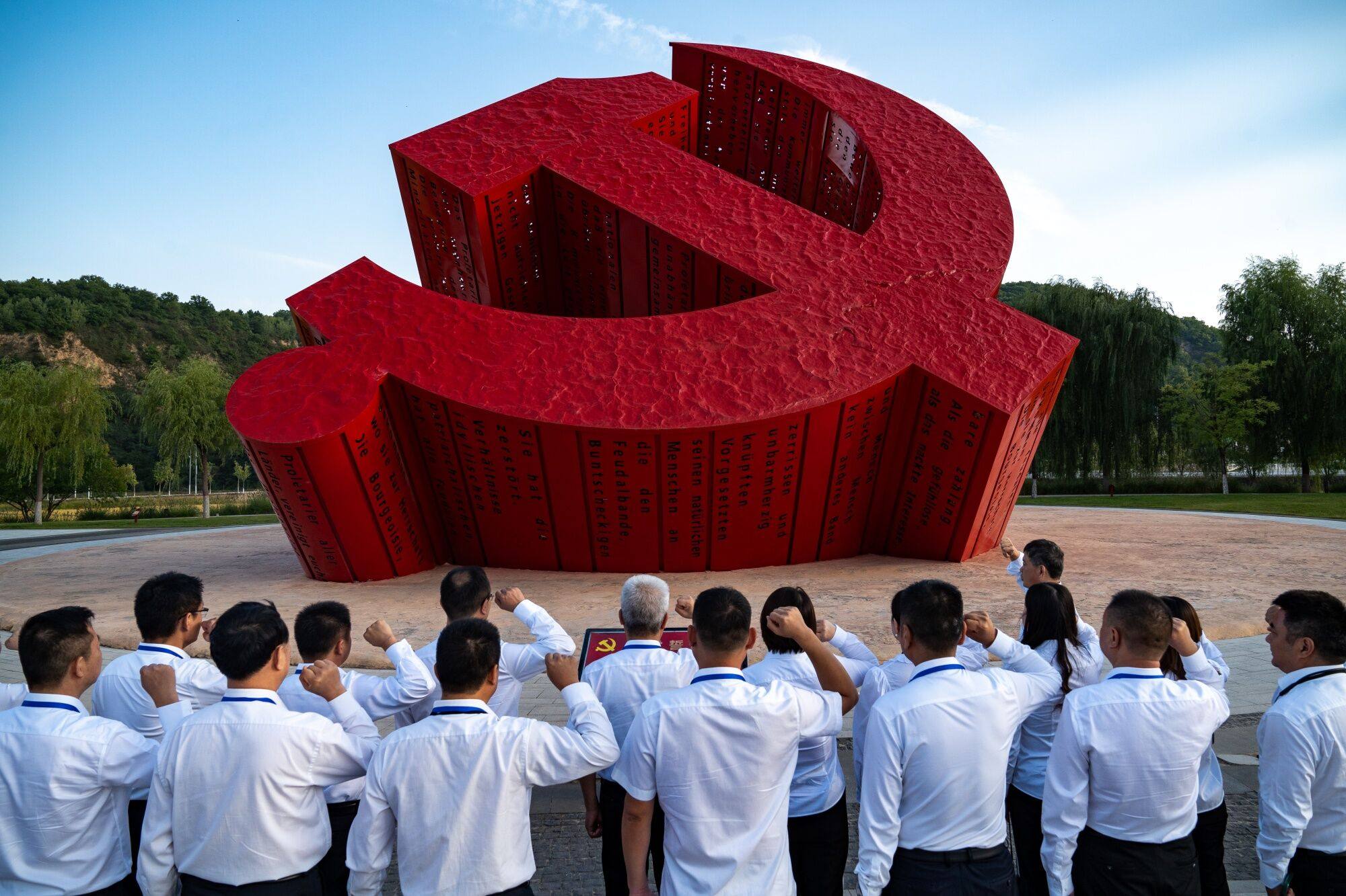 Visitors recite the admission oath of the Communist Party in front of the party emblem in China’s Shaanxi province on Tuesday. President Xi Jinping on Thursday vowed that officials across the country should not fear erring on their path toward development. Photo: Bloomberg