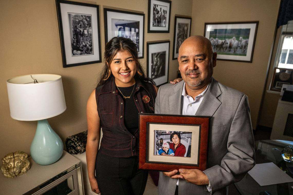 Alberto Torrico stands with his daughter Amy-Elizabeth, holding a photo of his mother and son Mateo. His mother is of Japanese descent from Bolivia. Photo: Hector Amezcua