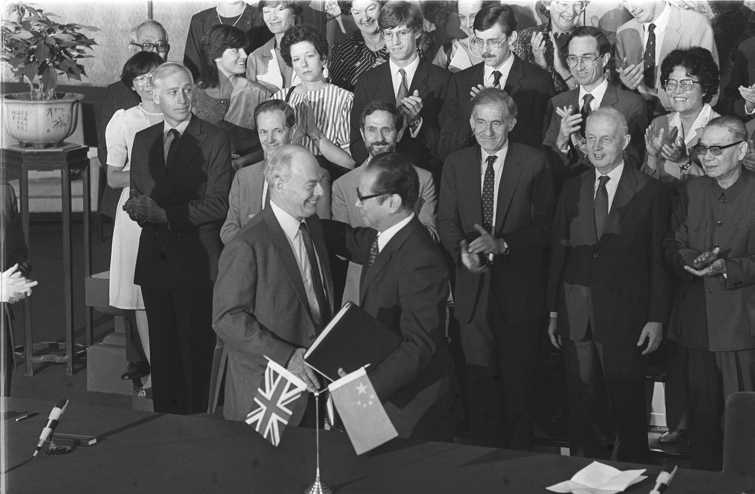 Richard Evans (left), the British ambassador to China, and Zhou Nan (right), chairman of the Chinese negotiating team, exchange documents at the initialling of the Sino-British draft agreement on September 26, 1984. Photo: P. Y. Tang