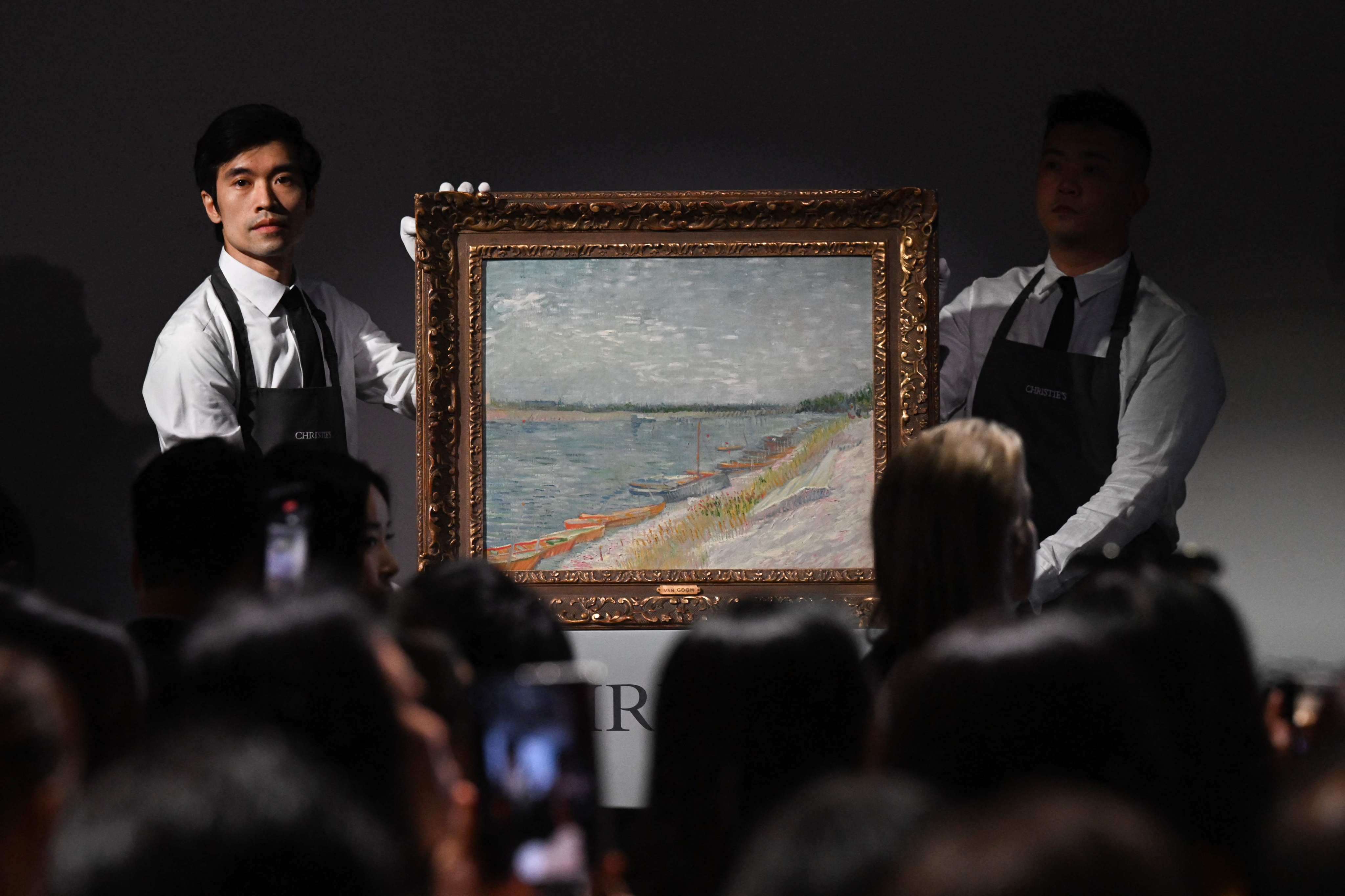 Auction staff hold up painting Les canots amarrés by Vincent Van Gogh, which sold at auction at Christie’s Hong Kong headquarters for HK$215 million (US$27.6 million) on September 26, 2024. Photo: AFP