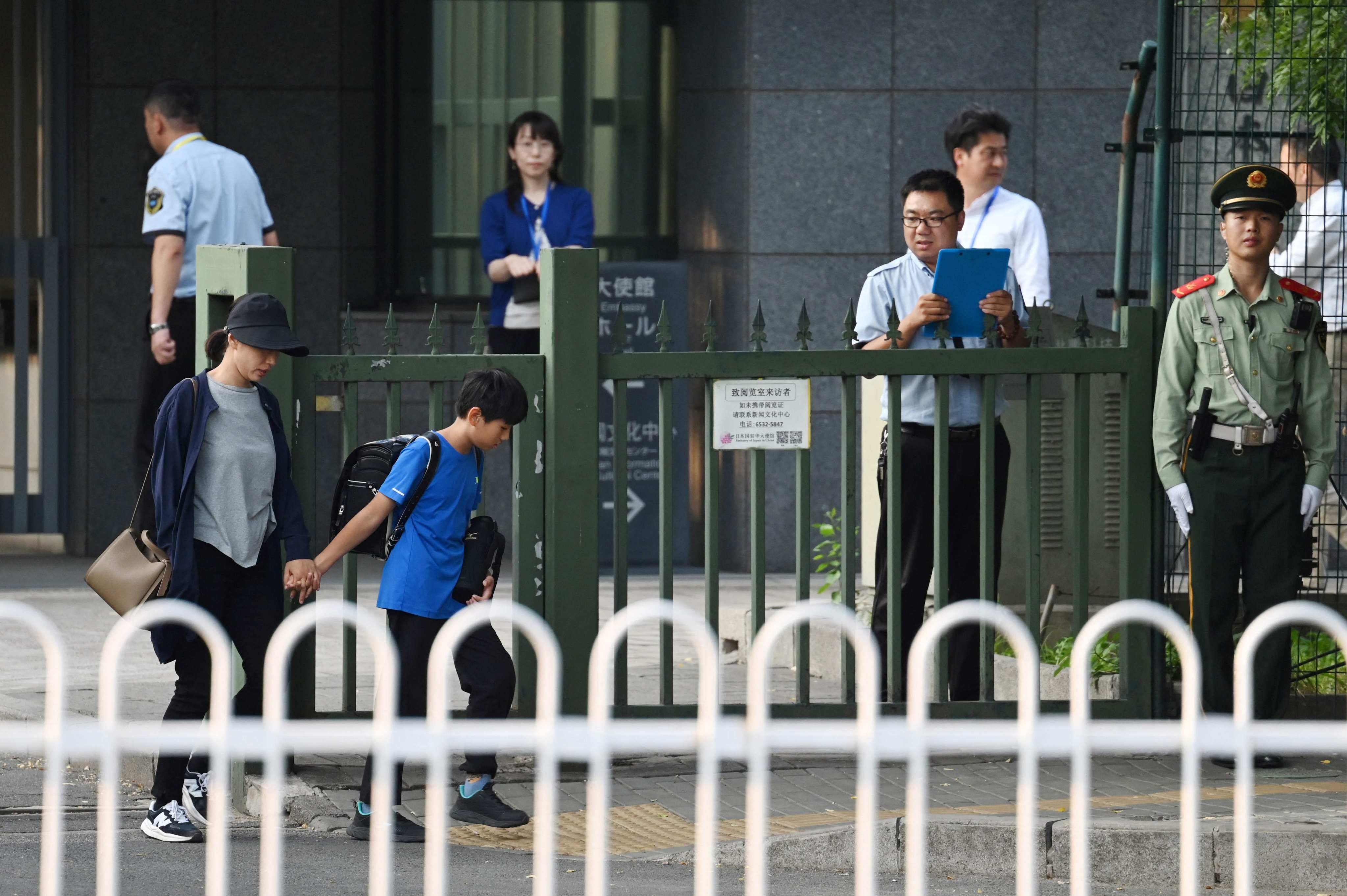 A woman and a boy leave the Japanese embassy in Beijing on September 19. China has expressed “regret and sadness” after a Japanese schoolboy who was stabbed in Shenzhen on the anniversary of the 918 Incident died of his injuries. Photo: AFP