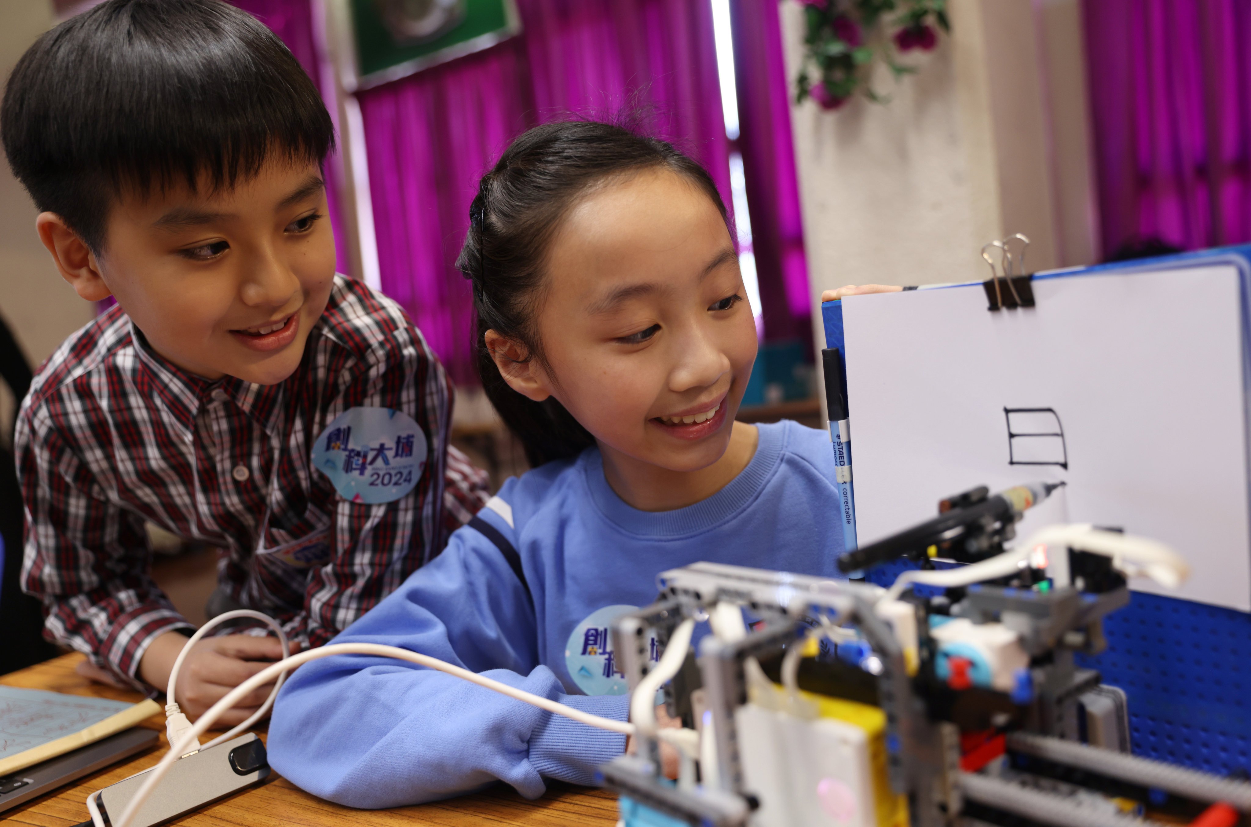 Two pupils from Hong Kong show their work at a press conference on January 16, ahead of an expo to showcase the innovative works by young inventors. Photo: Yik Yeung-man