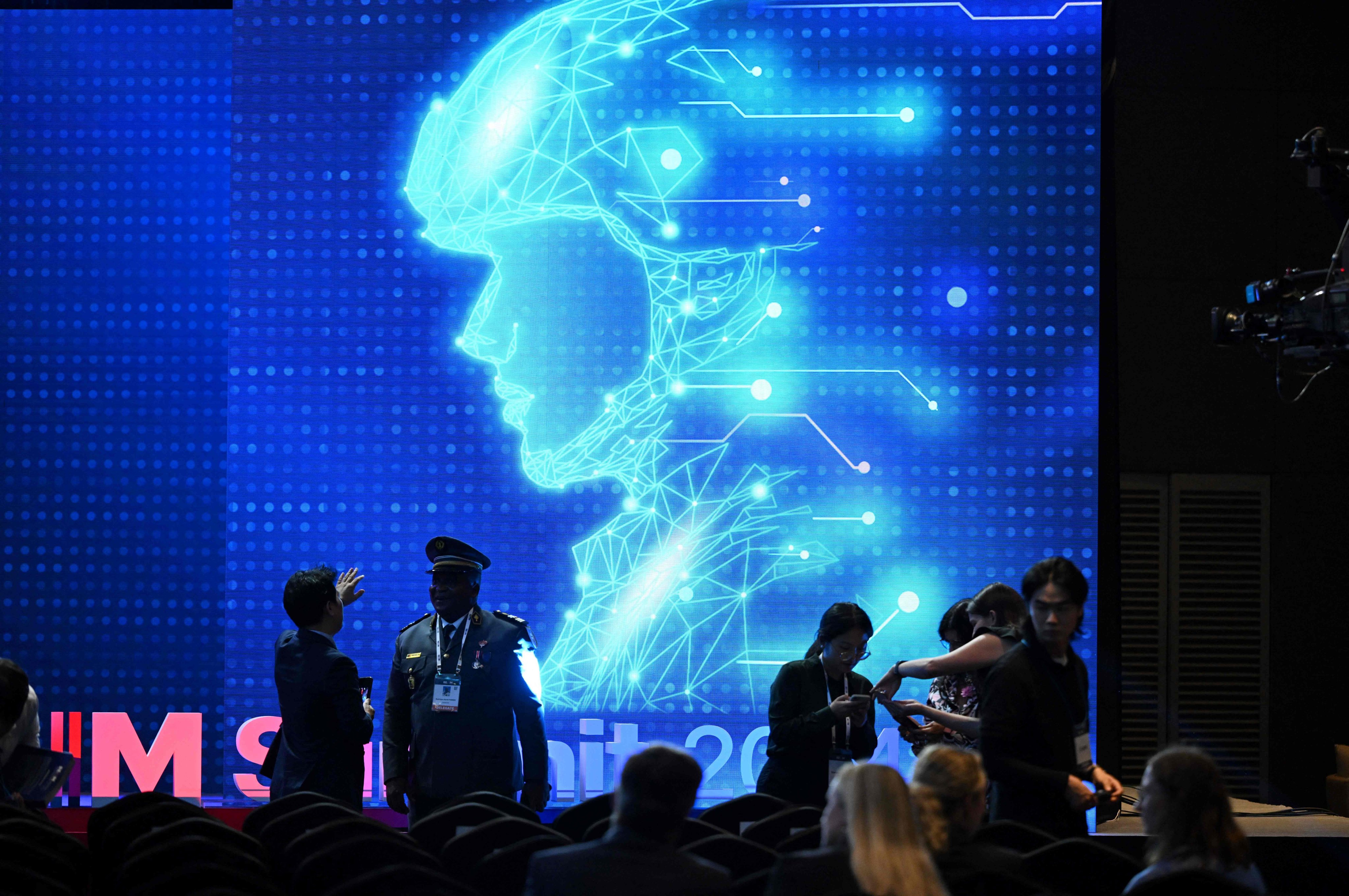 Participants chat in front of an electronic image of a soldier at a summit titled Responsible AI in the Military Domain, in Seoul on September 10. Humans, not artificial intelligence, should make the key decisions on using nuclear weapons, it was agreed in a non-binding declaration. Photo: AFP