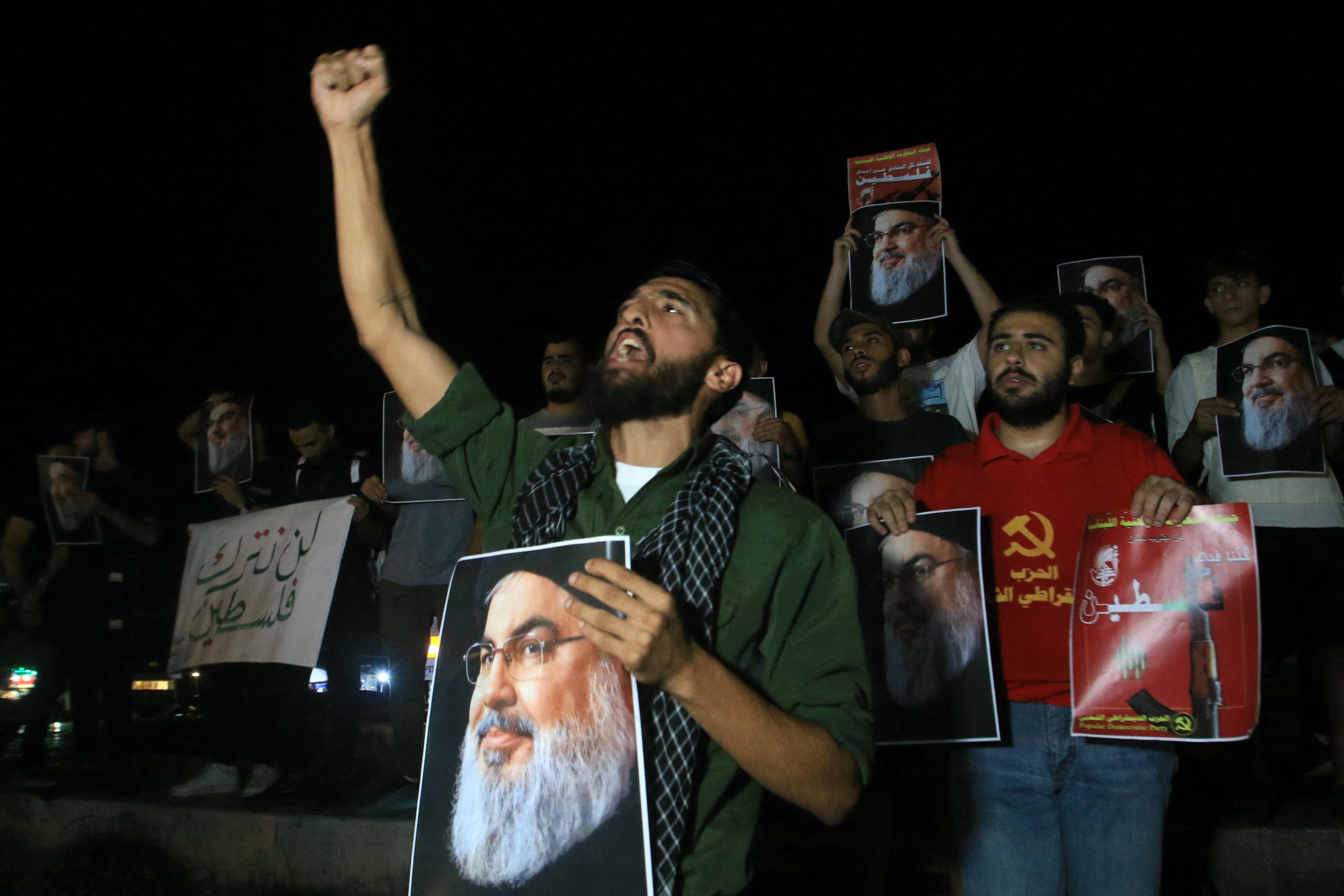 Demonstrators hold pictures of late Hezbollah leader Hassan Nasrallah during a protest vigil in the southern Lebanese city of Sidon on Saturday. Photo: AFP