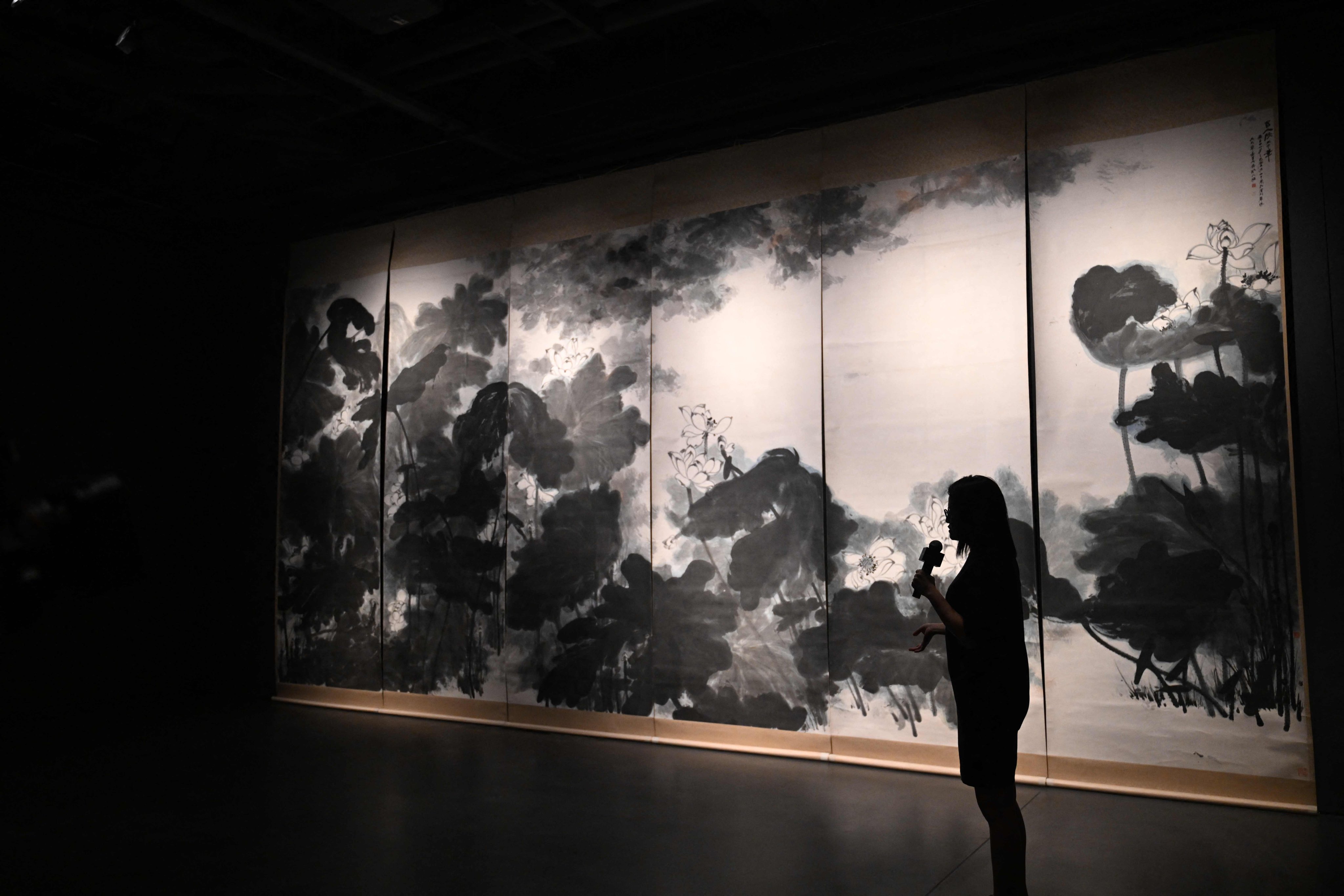 A Sotheby’s art expert speaks in front of Chinese artist Chang Dai-chien’s masterpiece “The Giant Lotuses” in Hong Kong on September 13. At over 3 metres tall and 8 metres wide, it is the largest known work created by the artist. This was the first time it had been seen in Asia. Photo: AFP