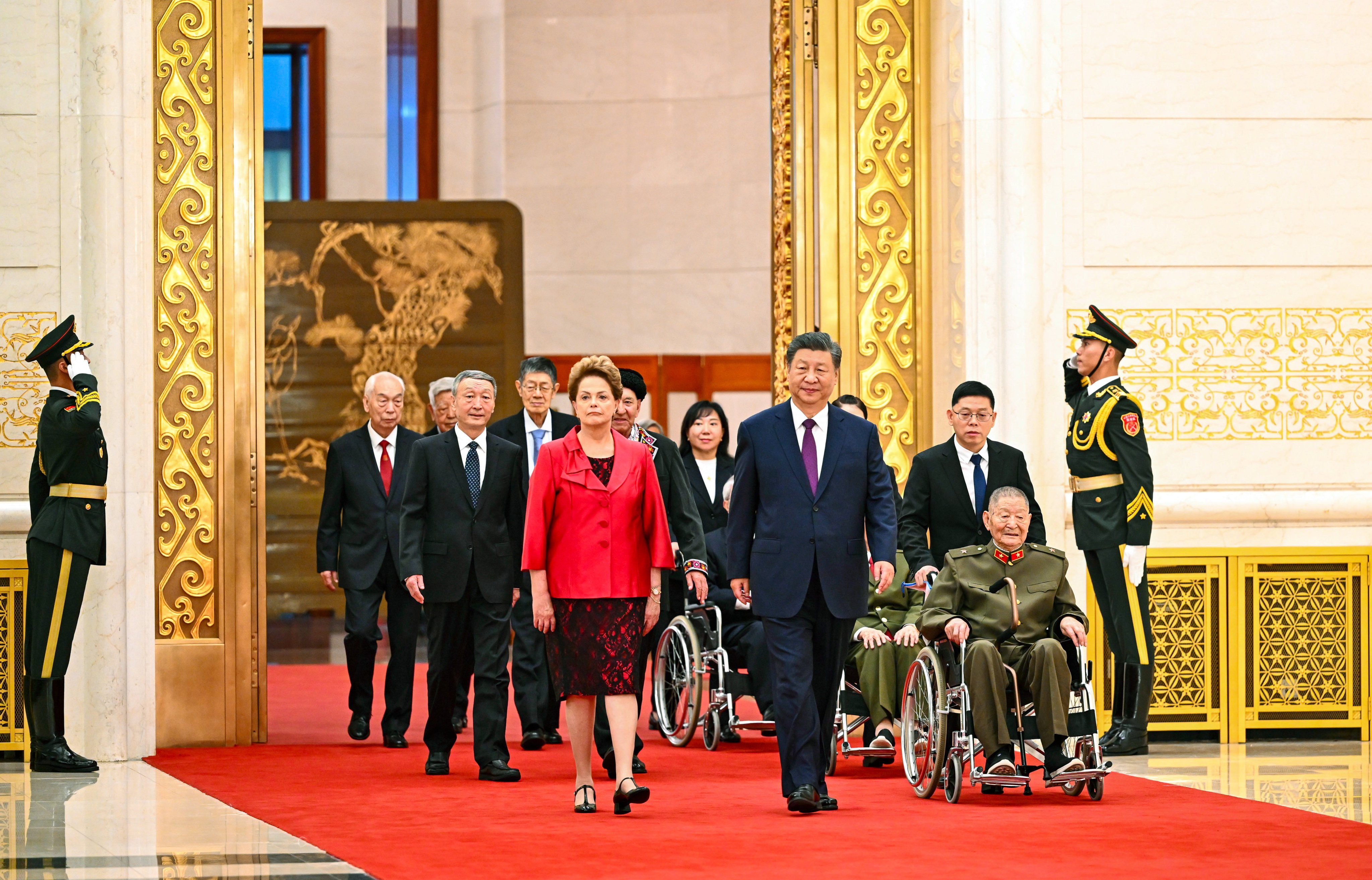 President Xi Jinping arrives for the awards ceremony alongside recipients including former Brazilian president Dilma Rousseff and war hero Huang Zongde (in wheelchair), at the Great Hall of the People in Beijing on Sunday. Photo: Xinhua