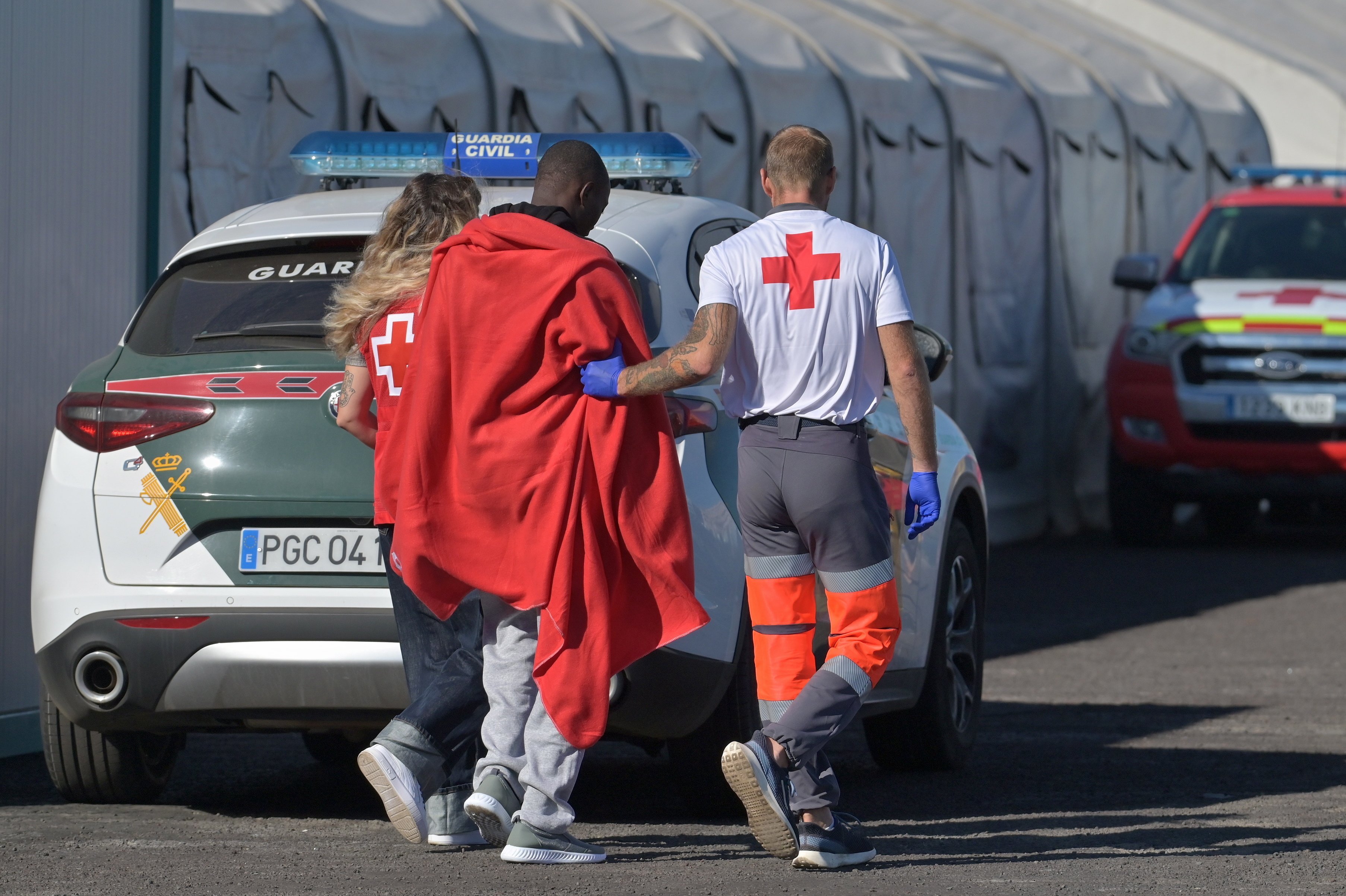 A rescued migrant is assisted by members of the Red Cross after arriving with 59 others on board a small wooden boat that departed from Mauritania, at La Restinga harbor in El Hierro island, Canaries, Spain. Photo: EPA/EFE