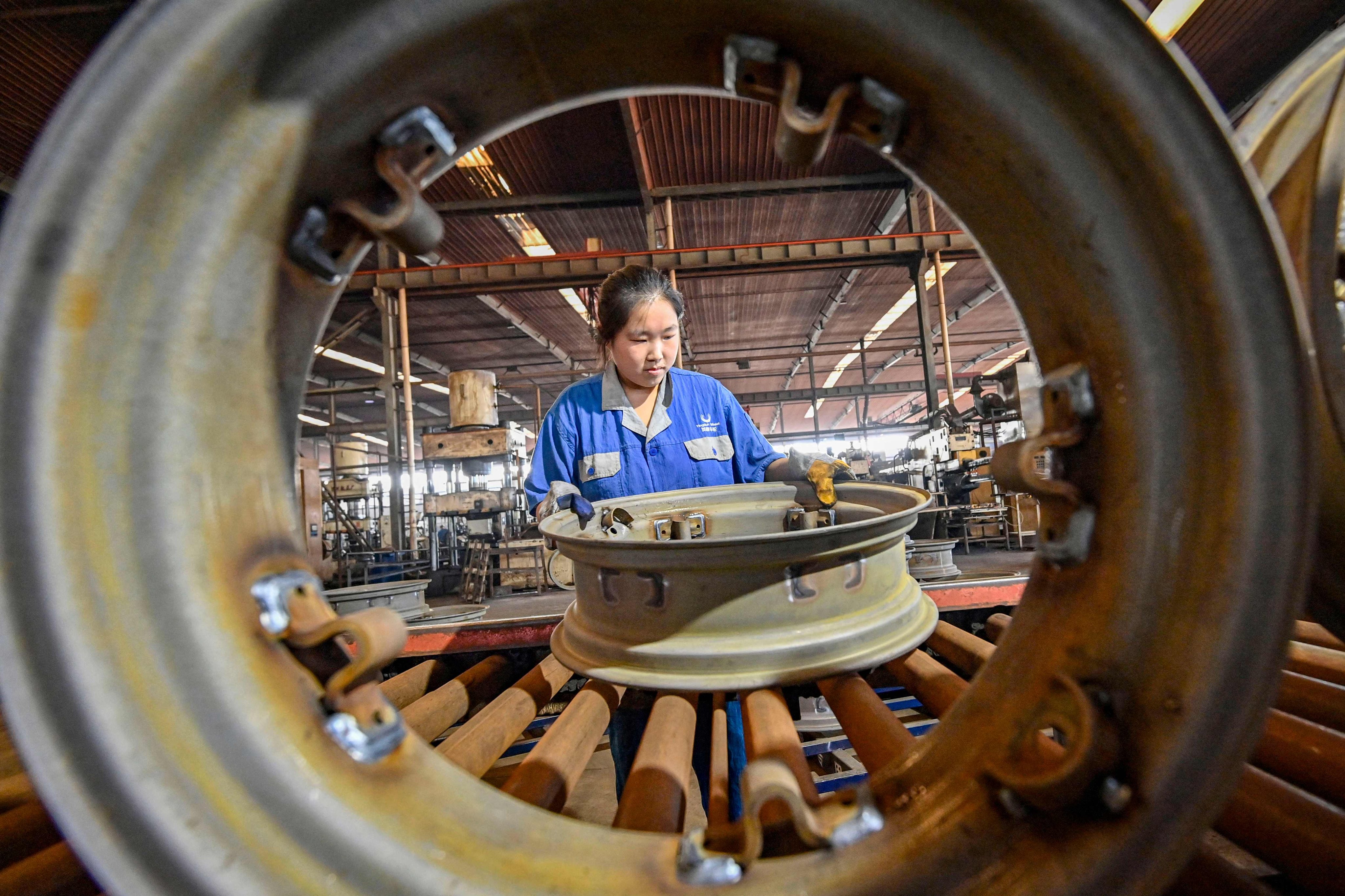 An employee works on a steel wheel production line at a factory in Qingzhou, in eastern China’s Shandong province. Photo: AFP