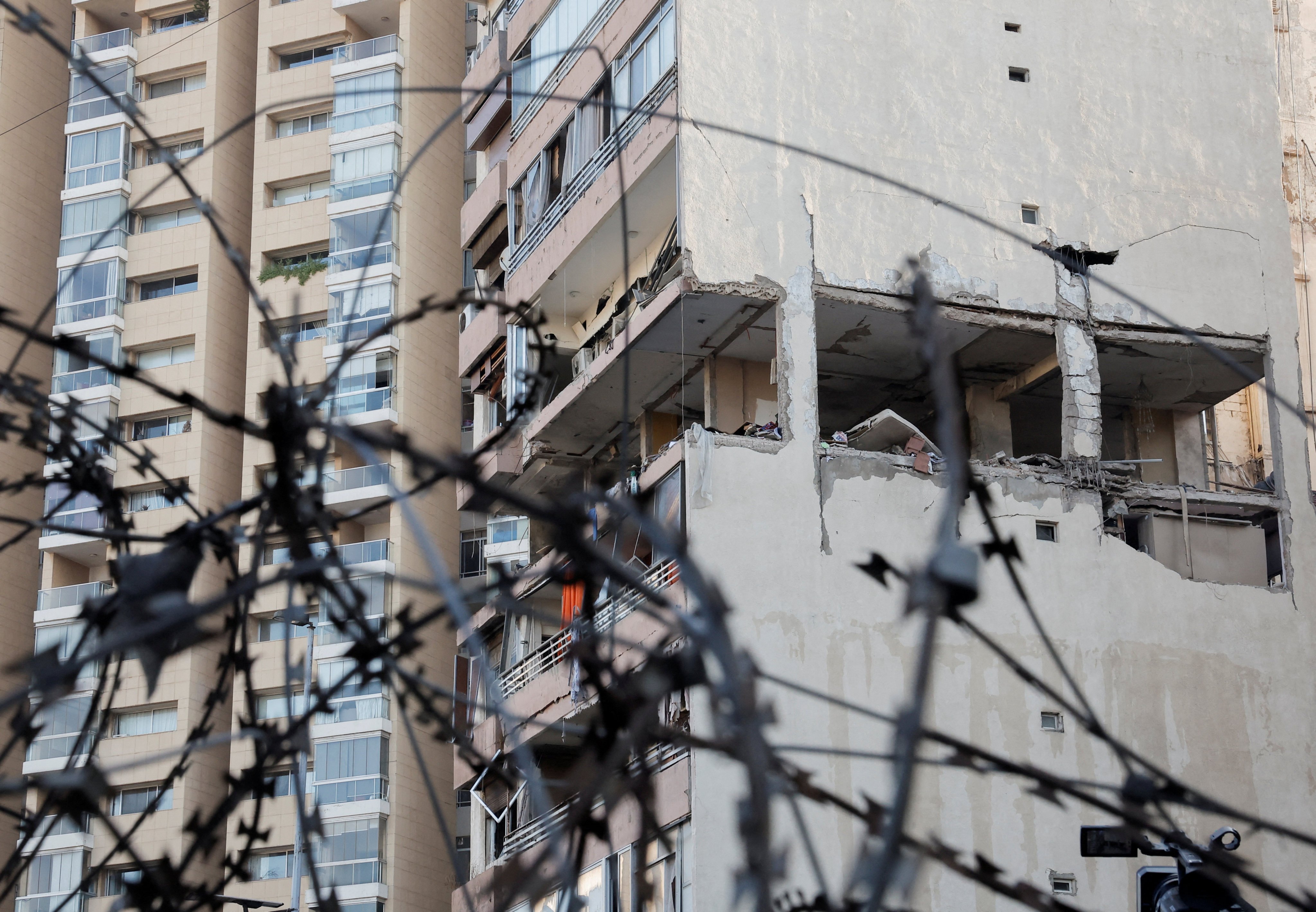 A building damaged in an Israeli strike, as seen through a razor wire fence, in Kola, central Beirut, Lebanon. Photo: Reuters