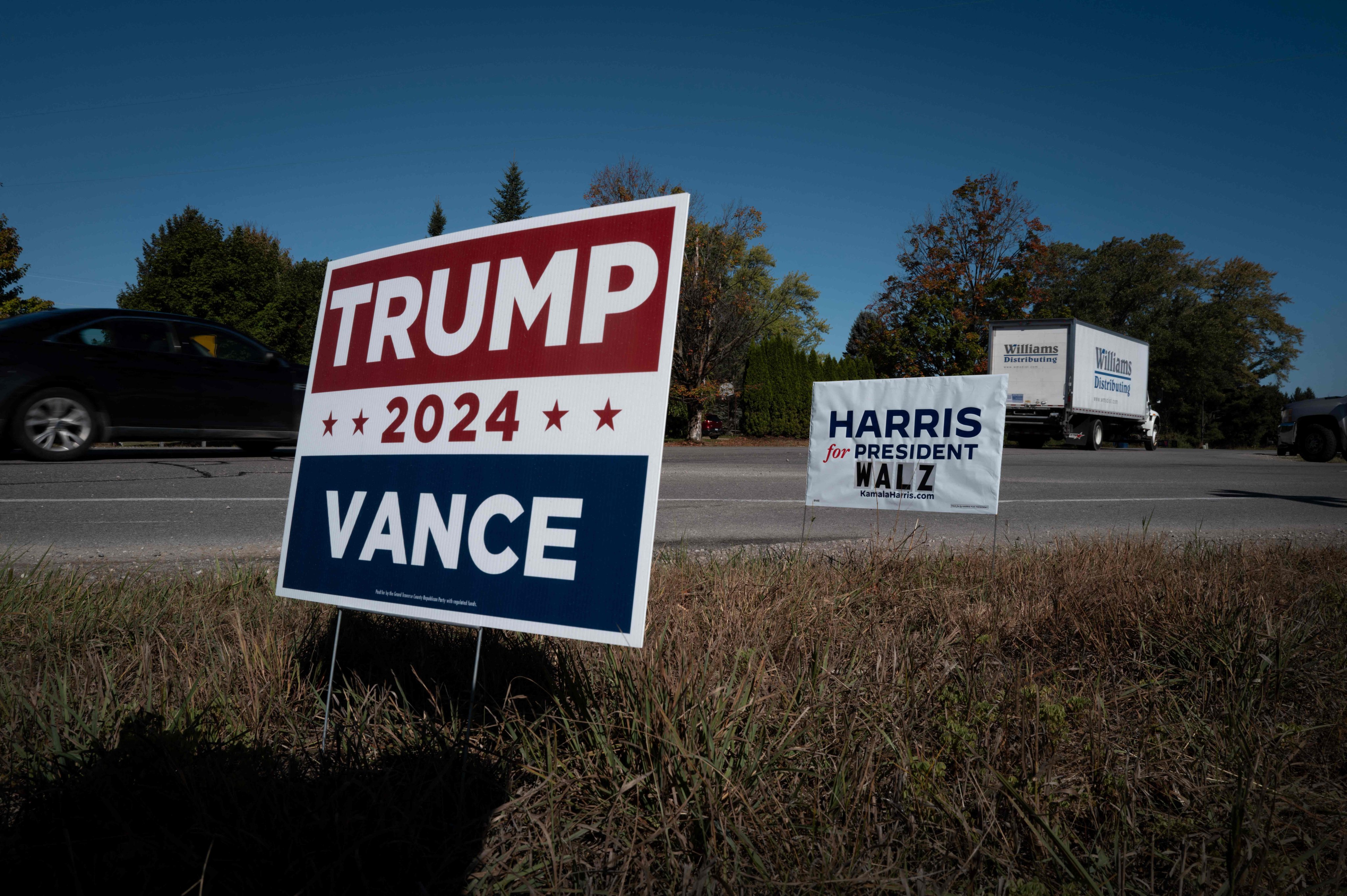 Signs showing support for both Democratic presidential candidate Vice-President Kamala Harris and Republican presidential candidate former President Donald Trump sit along a rural highwar near Traverse City, Michigan. Photo: Getty Images via AFP