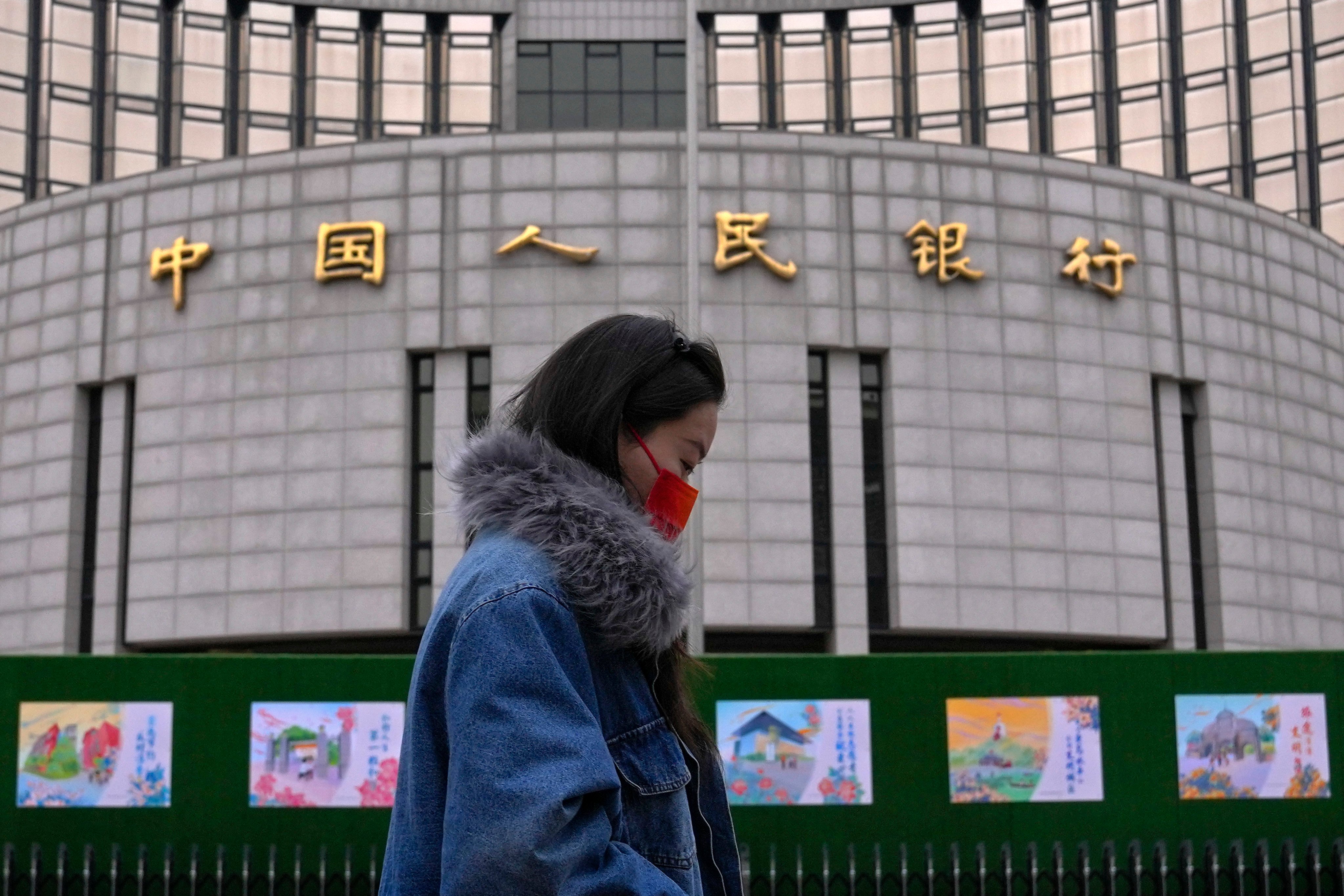 A woman walks by the People’s Bank of China in Beijing, on February 20. Photo: AP