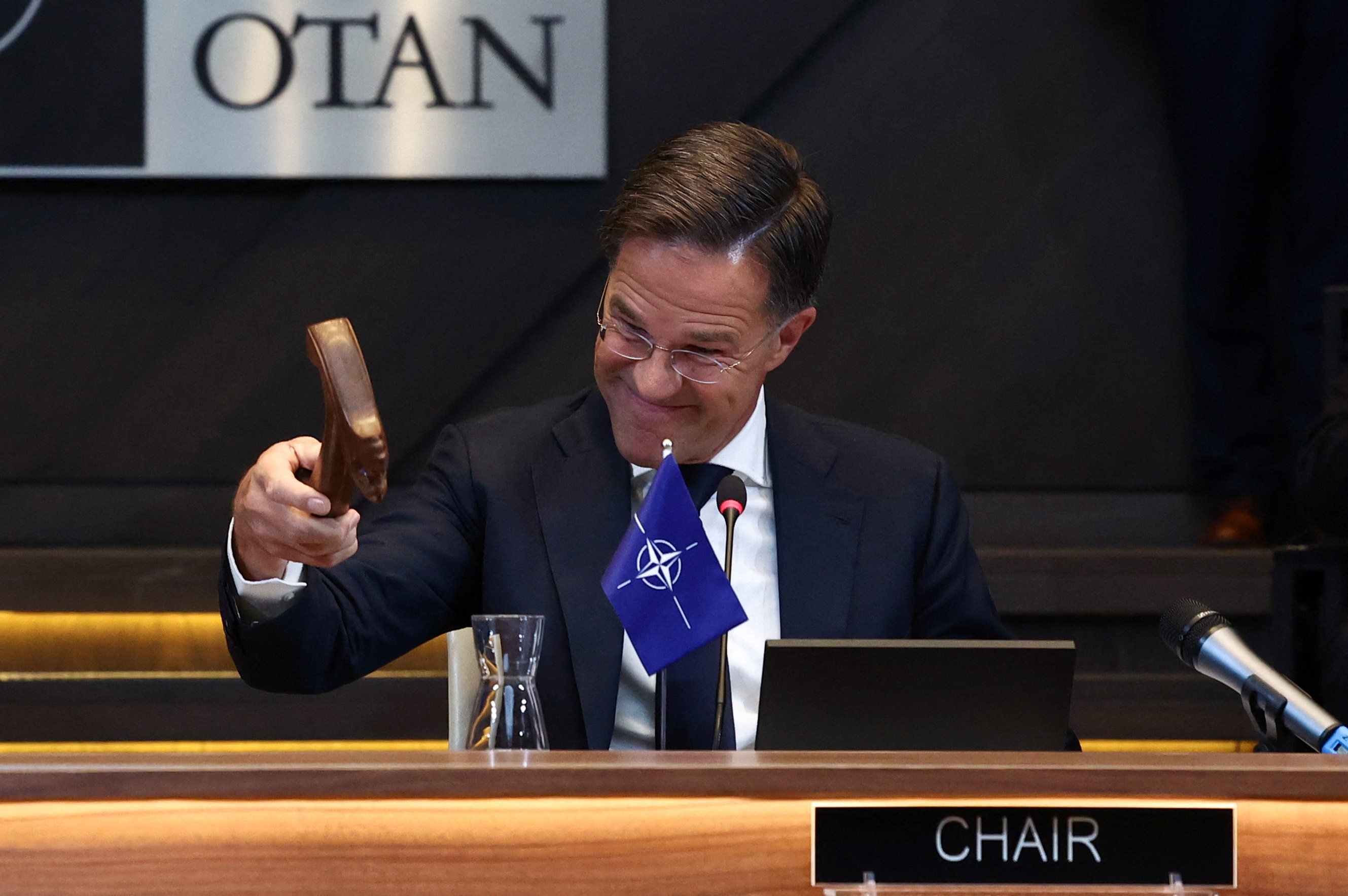 New Nato Secretary General Mark Rutte uses a hammer at a meeting of the North Atlantic Council in Brussels. Photo: Reuters