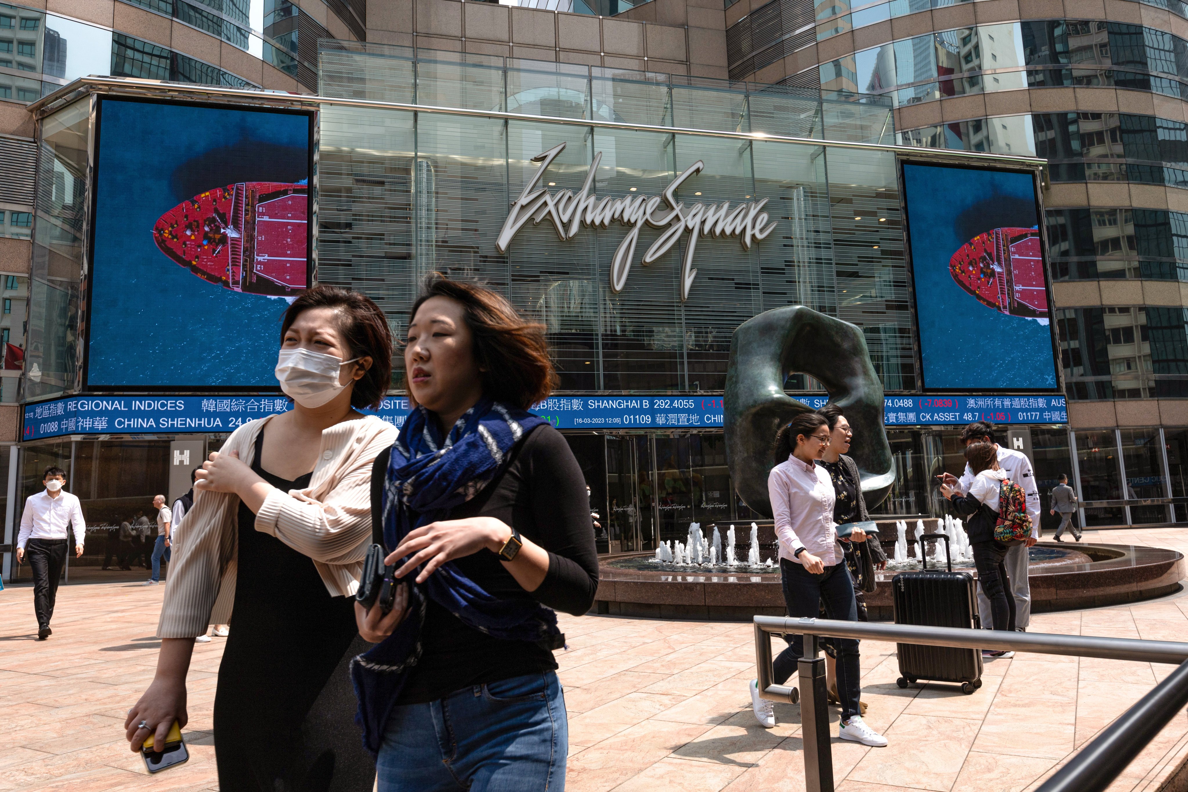 Pedestrians walk past a stock ticker outside the Exchange Square in Central. Photo: EPA-EFE