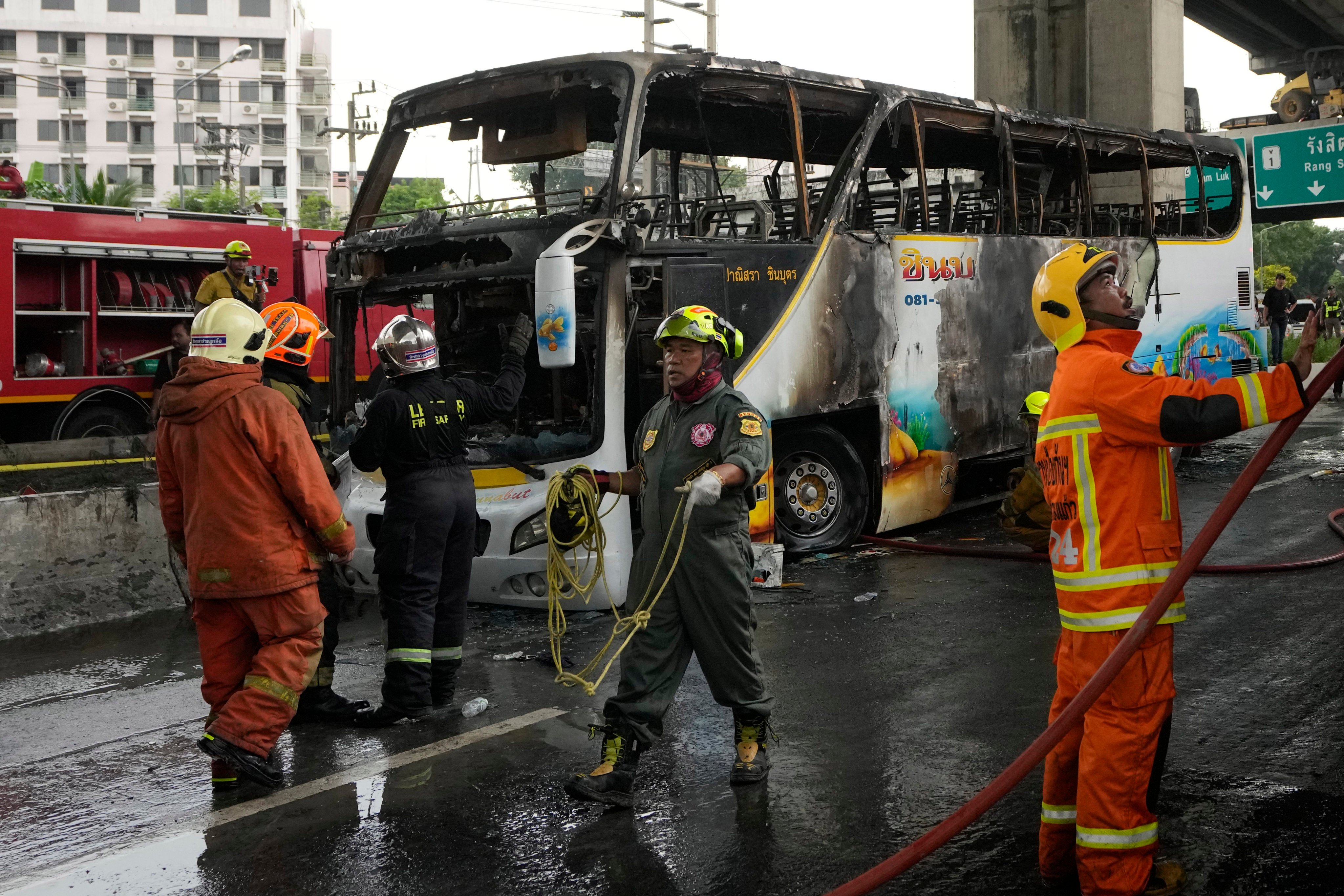 Rescuers work at the site of a bus that caught fire, carrying young students with their teachers, in suburban Bangkok on Ocober 1. Photo: AP