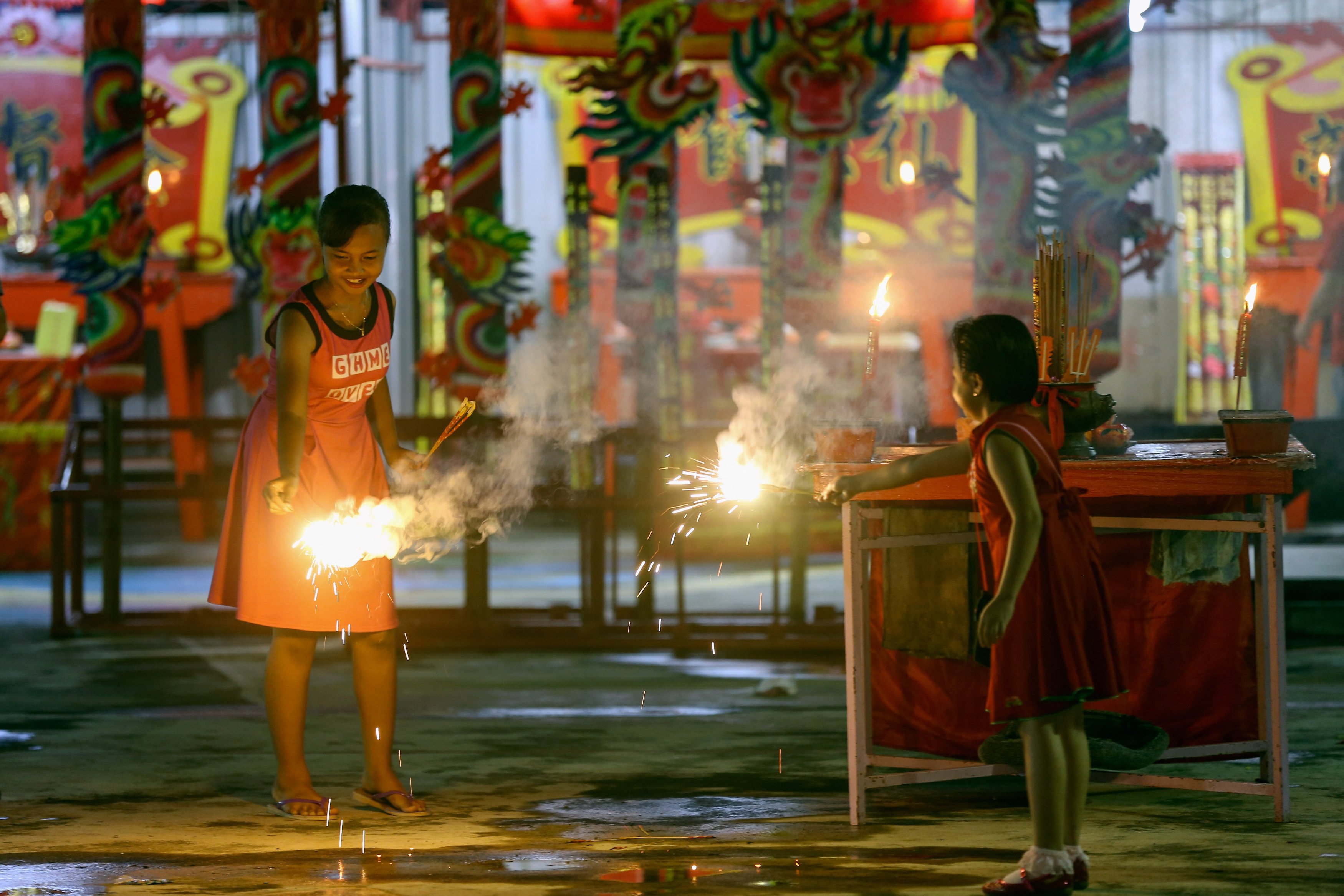 Children play with firecrackers in a temple ahead of Lunar New Year celebrations outside Kuala Lumpur in Malaysia in 2017. Photo: Getty Images