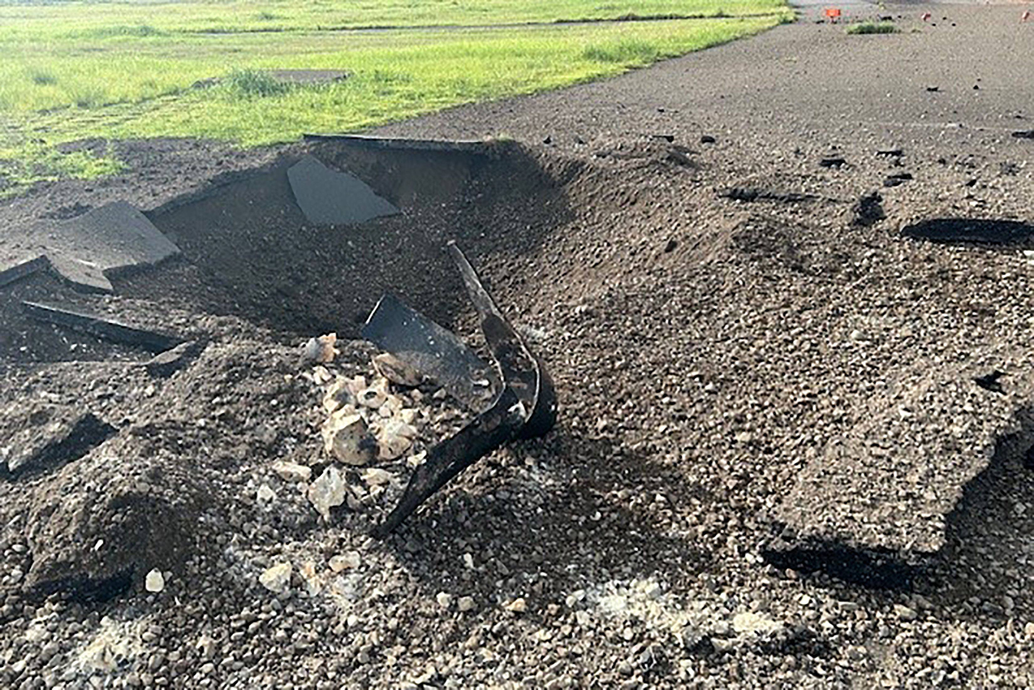 Debris on the edge of the airport tarmac after an unexploded World War II US bomb blew up less than a minute after a passenger jet taxied past on October 2 at Miyazaki Airport in southern Kyushu, Japan. Photo: Miyazaki Airport Office of the Ministry of Land, Infrastructure, Transport and Tourism / AFP