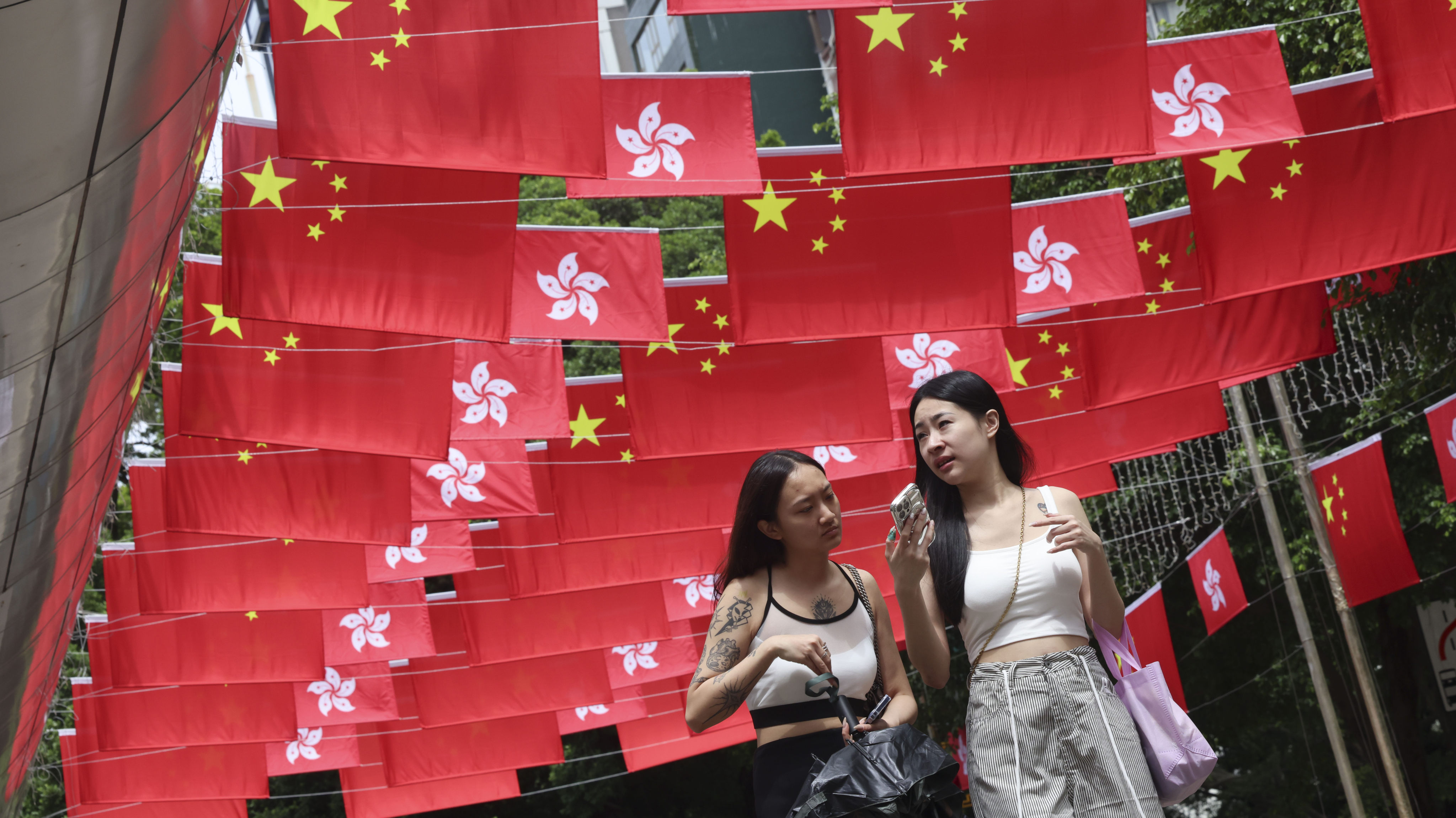 People walk along a street in Tsim Sha Tsui decorated with national and Hong Kong Special Administrative Region flags on September 25 to celebrate the 75th anniversary of the founding of the People’s Republic of China on October 1. Photo: Jelly Tse