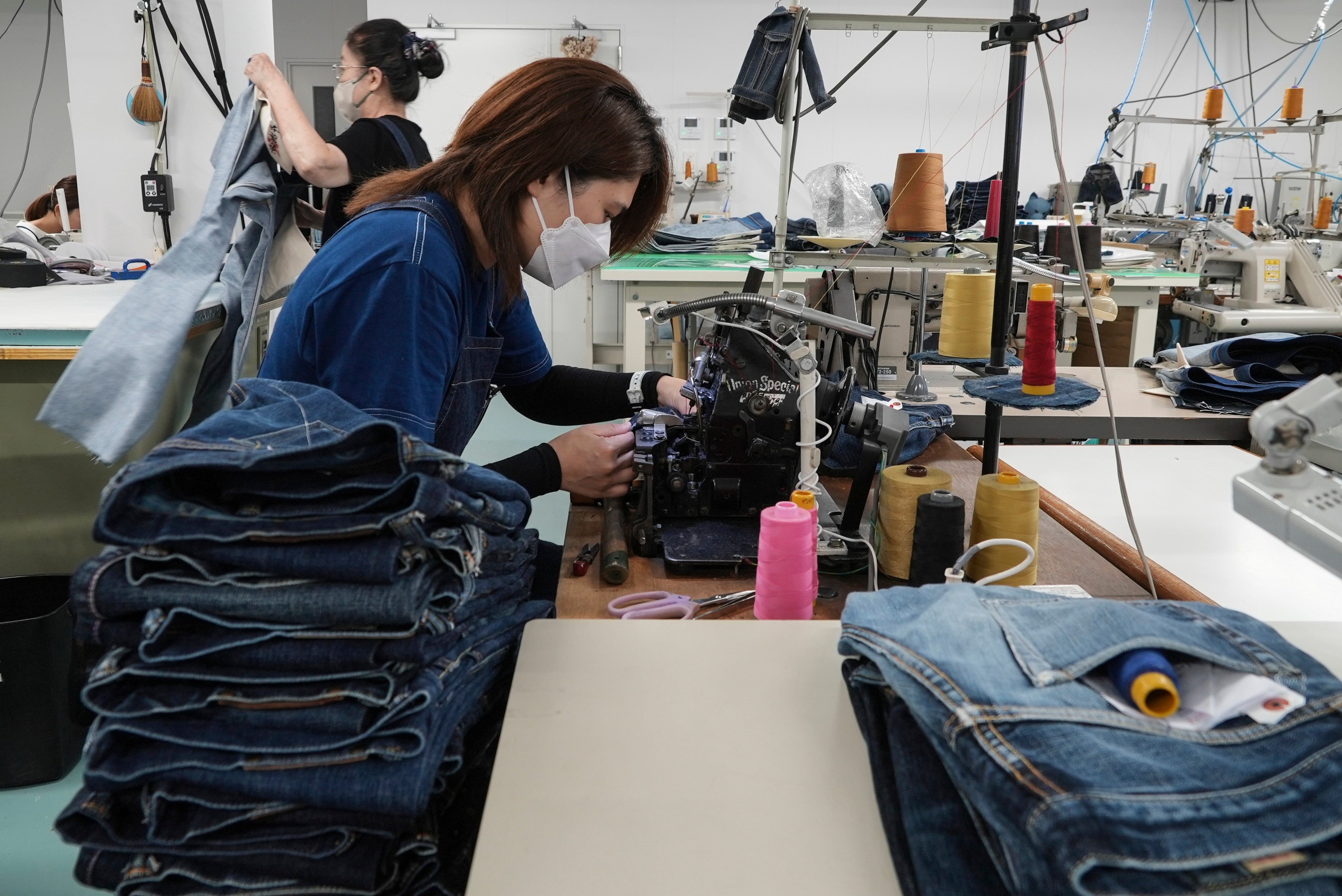 A seamstress at Momotaro Jeans makes jeans using a vintage sewing machine. Photo: AP