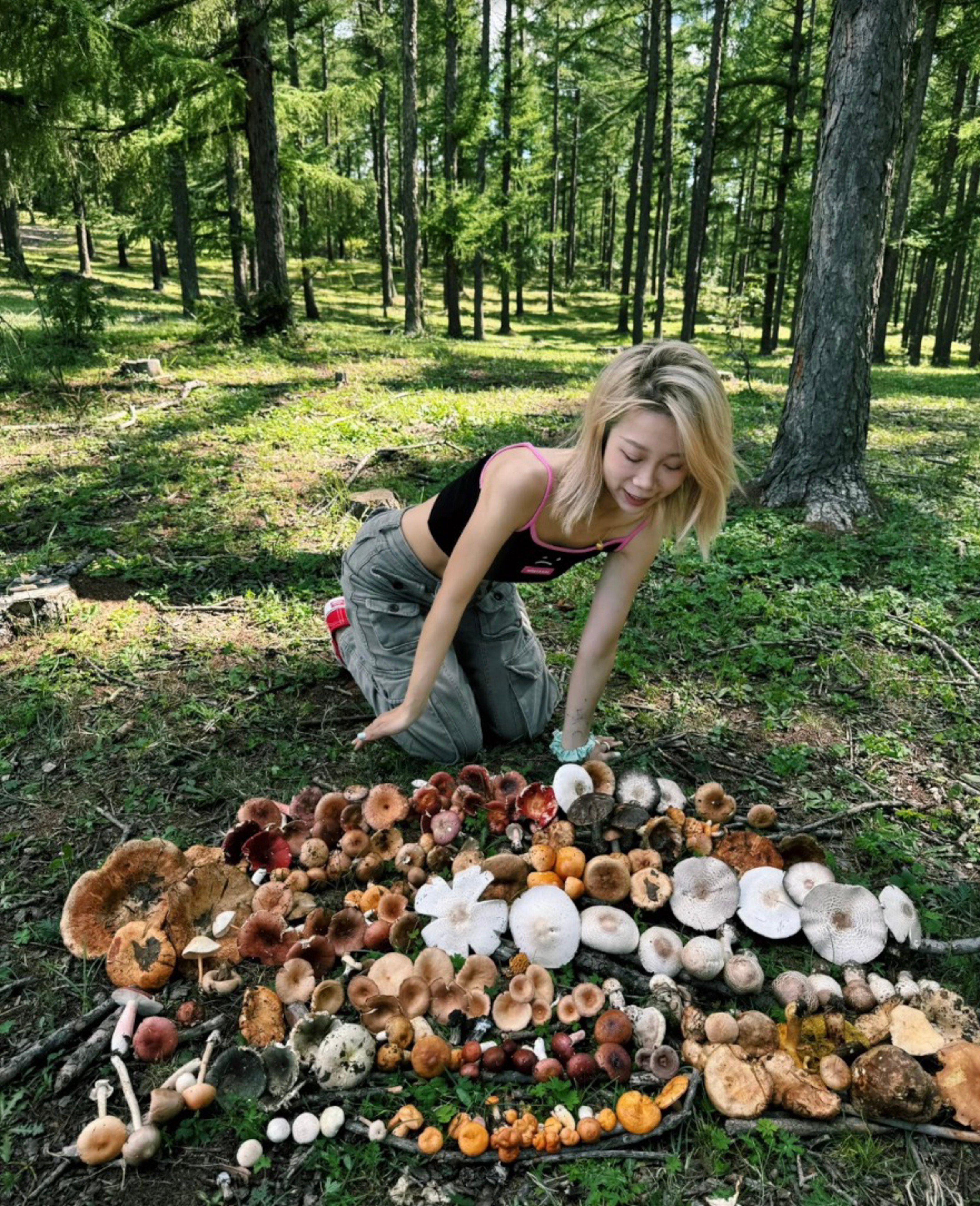 A woman poses with her mushroom collection in a forest near Beijing. Mushroom foraging has become a new viral hobby in China. Photo: Xiaohongshu