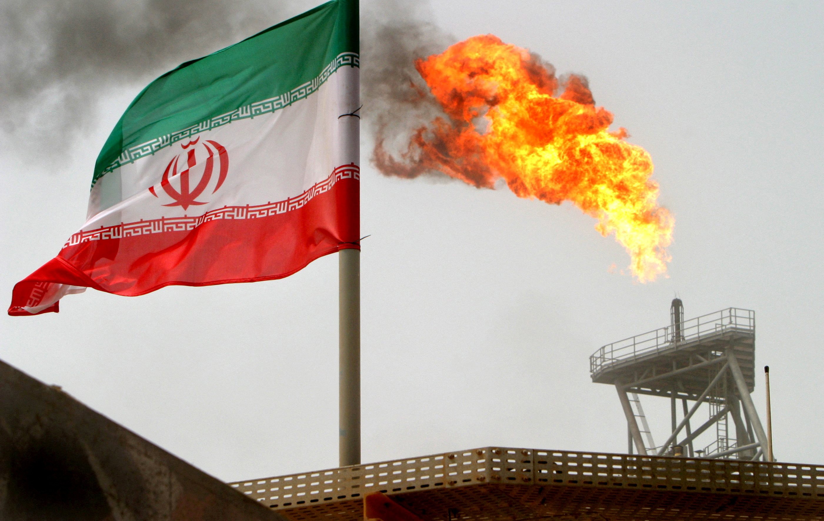 A gas flare on an oil production platform is seen alongside an Iranian flag in the Gulf in July 2005. Photo: Reuters