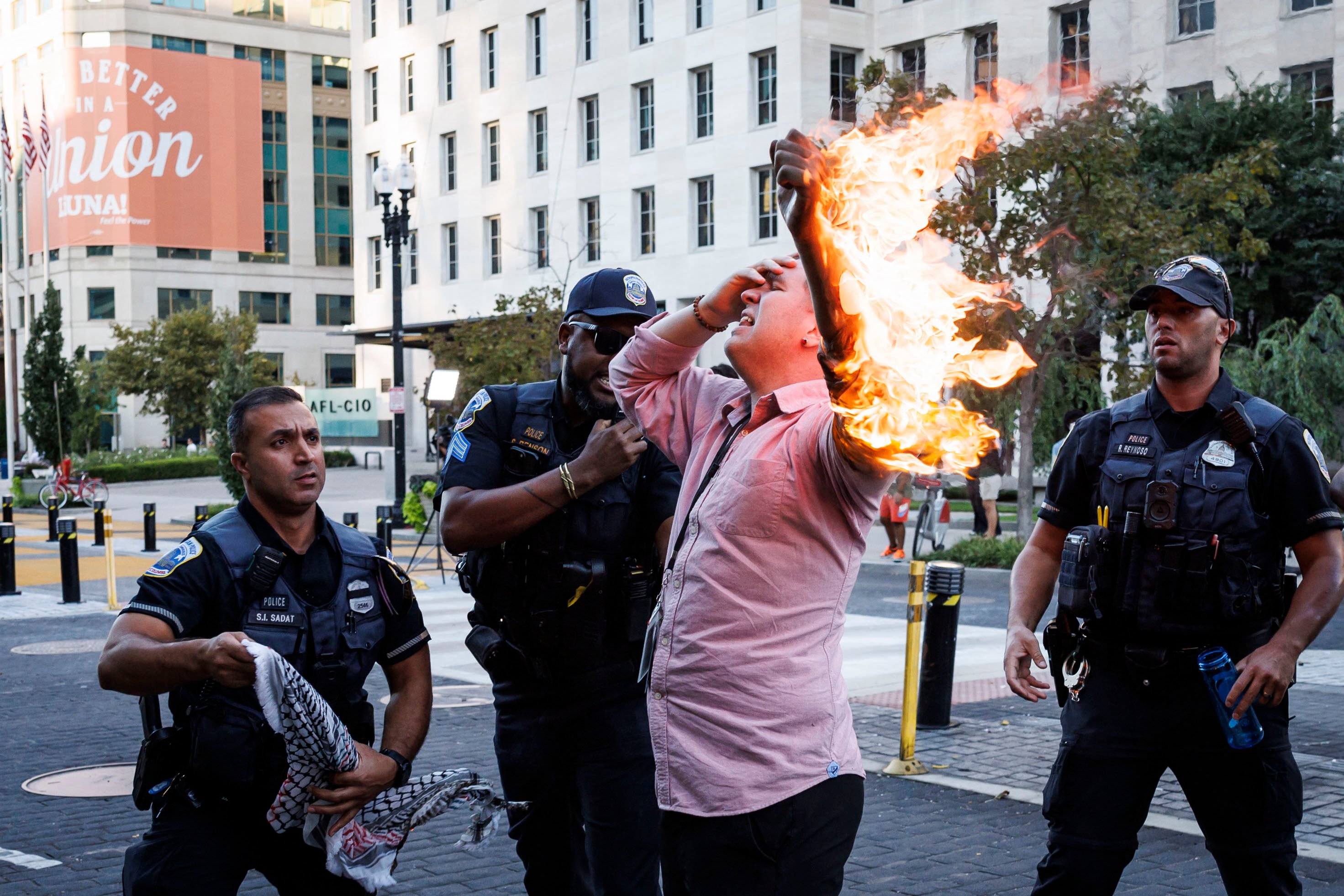 Police help a man who tried to set himself on fire as people demonstrate to mark one year of the war between Hamas and Israel near the White House. Photo: AFP