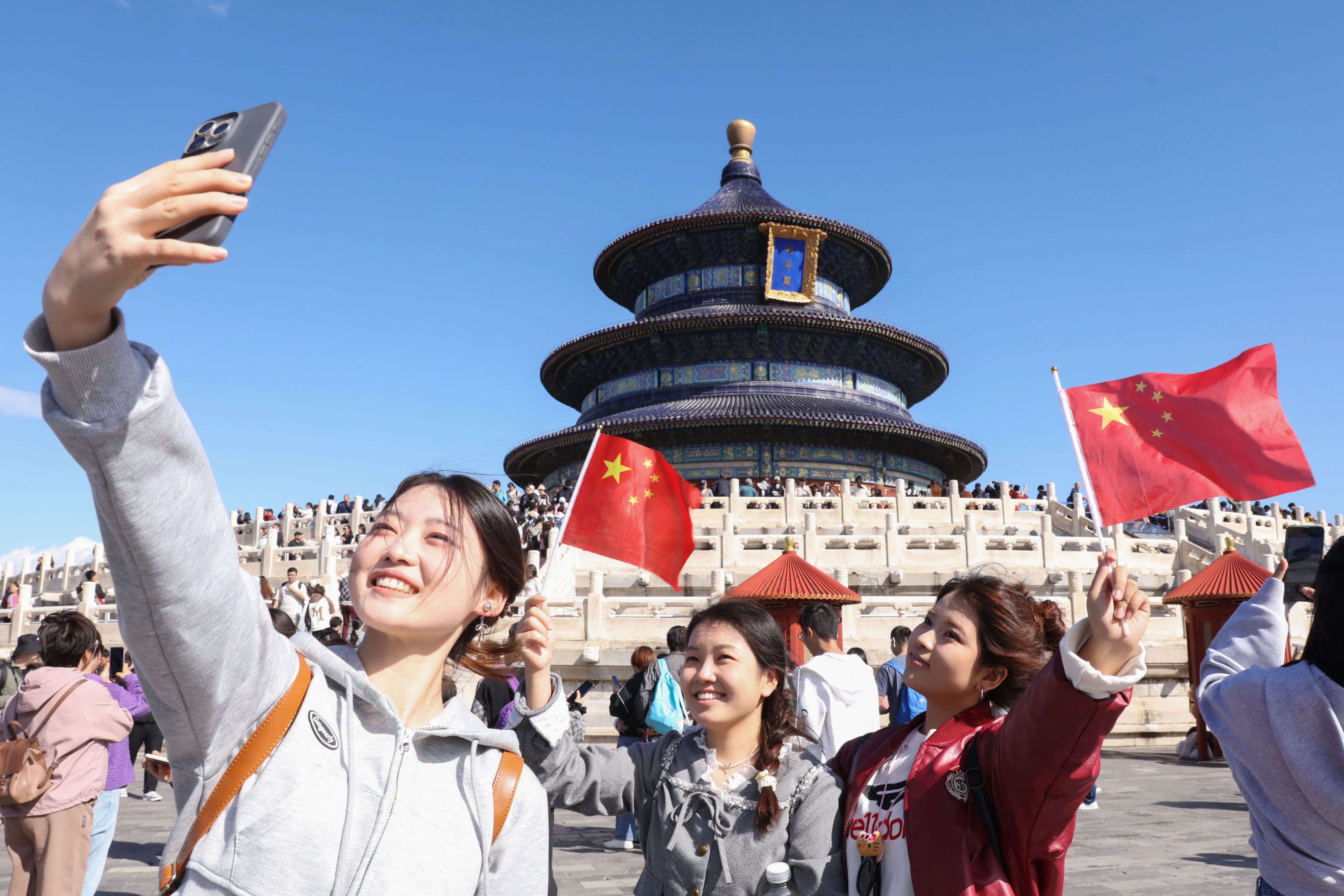 Holidaymakers take selfies at Tiantan Park in Beijing on National Day on October 1. Photo: Xinhua