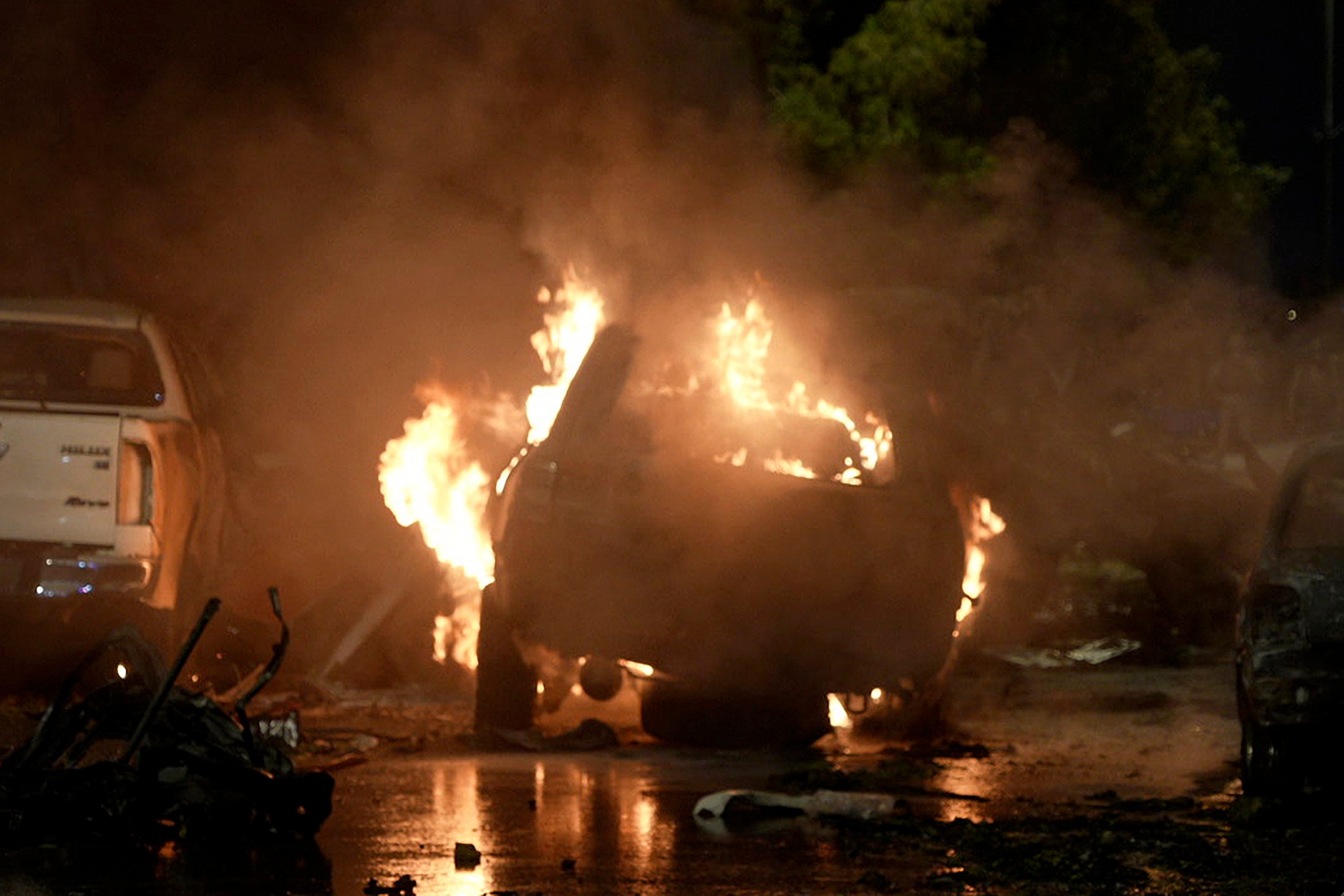 A vehicle is seen on fire at the site of an explosion that caused injures and destroyed vehicles outside Karachi airport in Pakistan on Sunday. Photo: AP