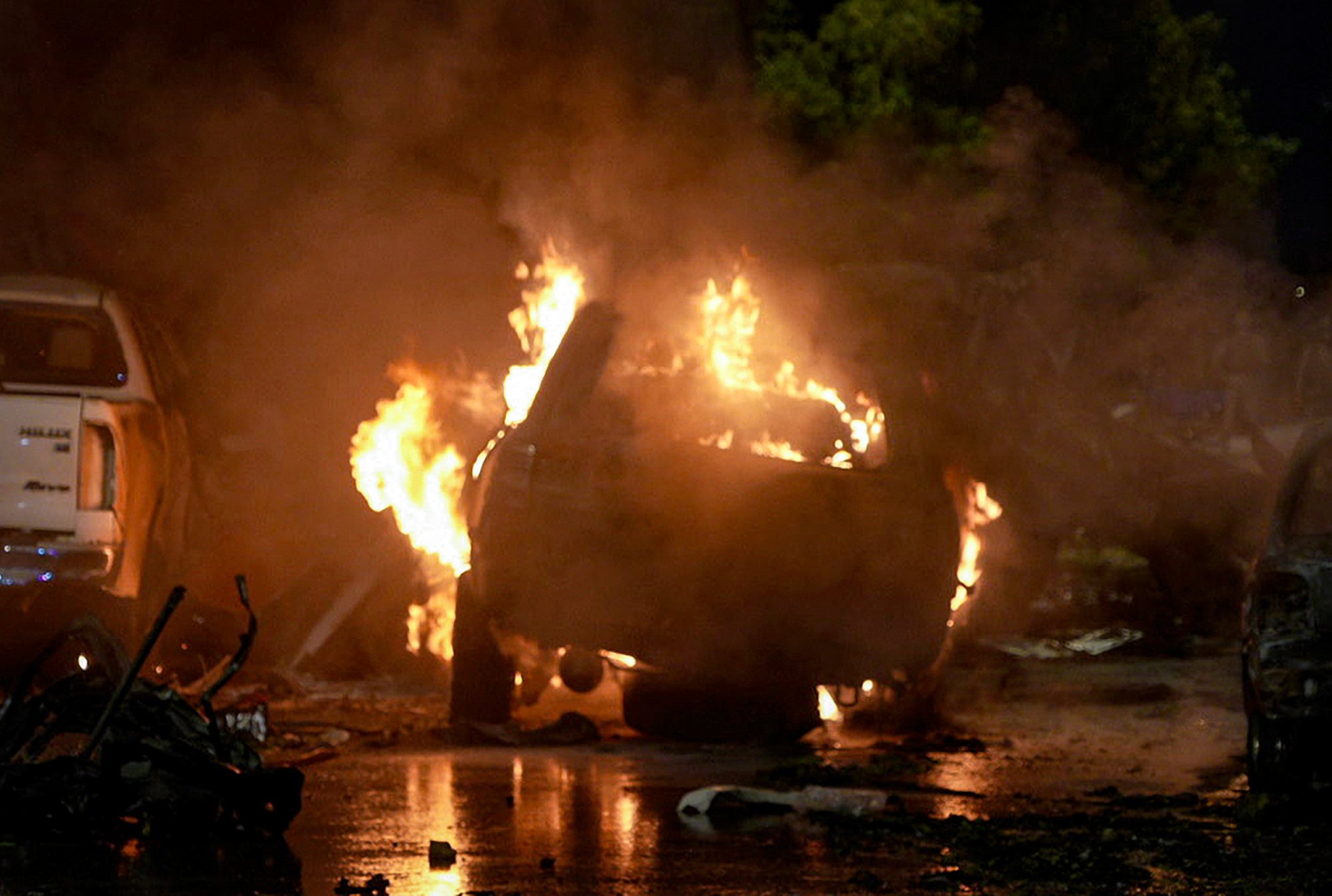 A vehicle is on fire at the site of a deadly explosion outside the Karachi international airport on Sunday. Photo: AP