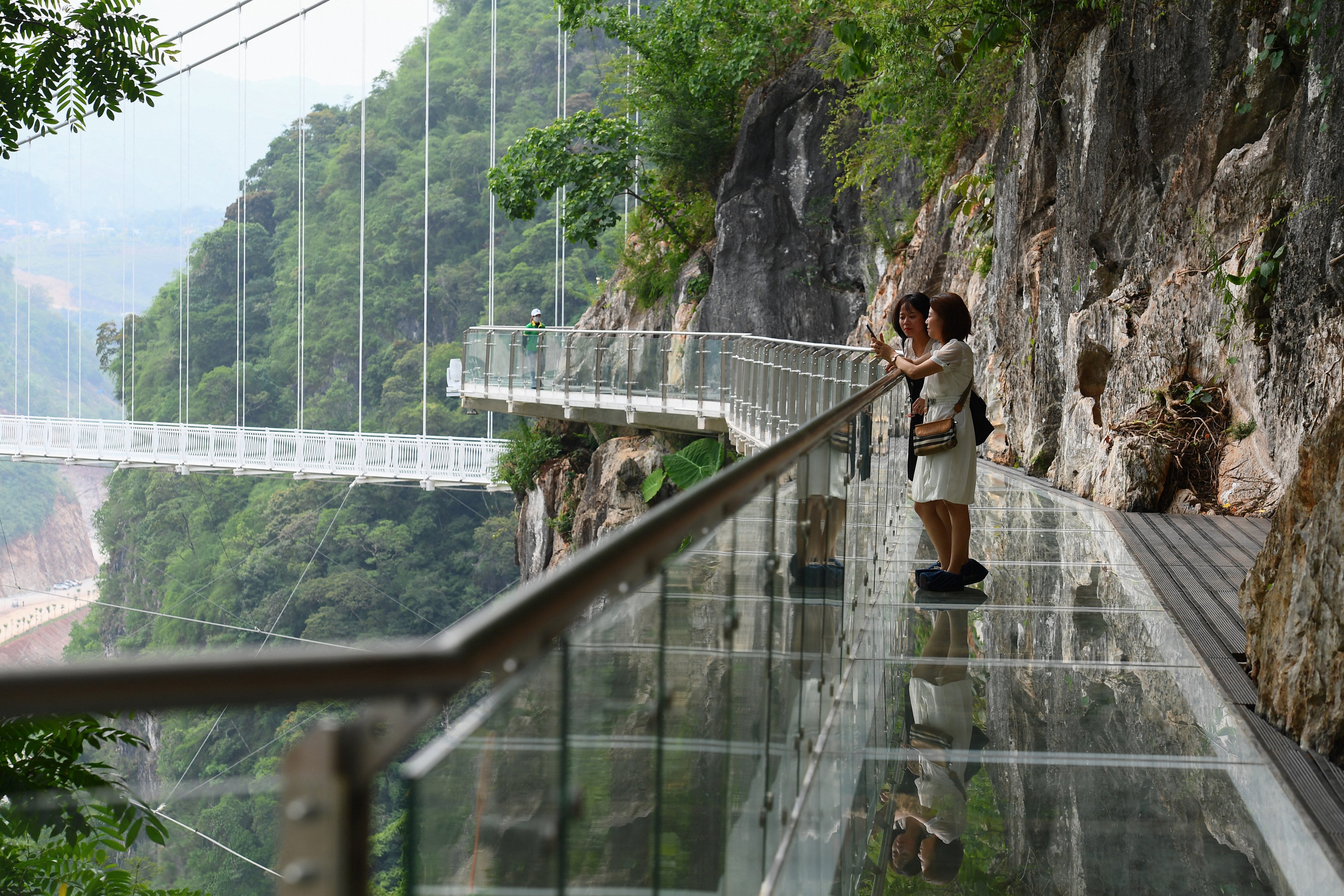 Visitors stand on the walkway section of the Bach Long glass bridge in Vietnam’s Son La province in April 2022. Vietnam is stepping up efforts to improve its soft power through increased tourism and making itself a destination for filmmakers. Photo: AFP