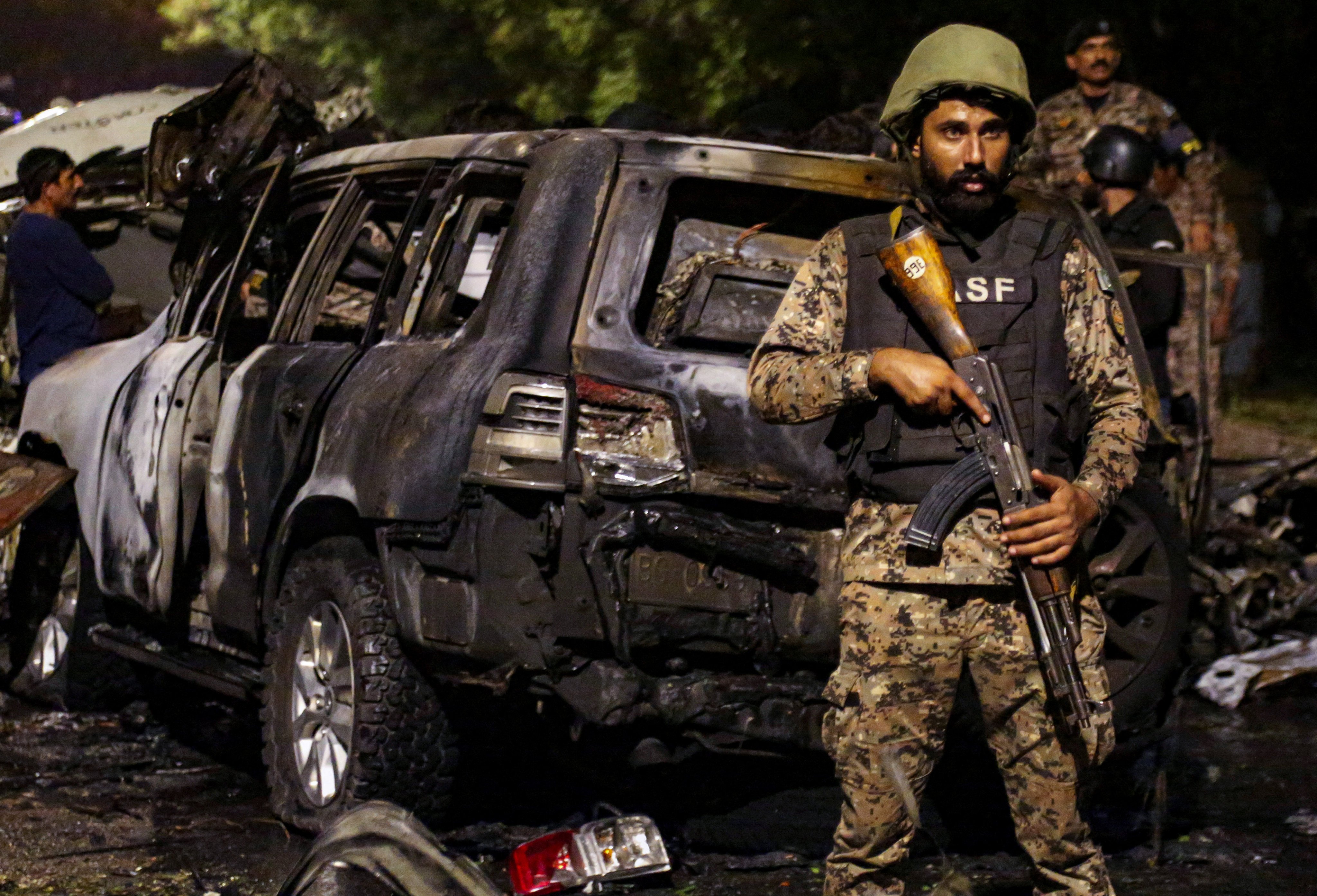 A Pakistan Airport Security Force member stands guard near the wreckage of vehicles after an explosion near Jinnah International Airport in Karachi on October 6, 2024. Photo: Reuters